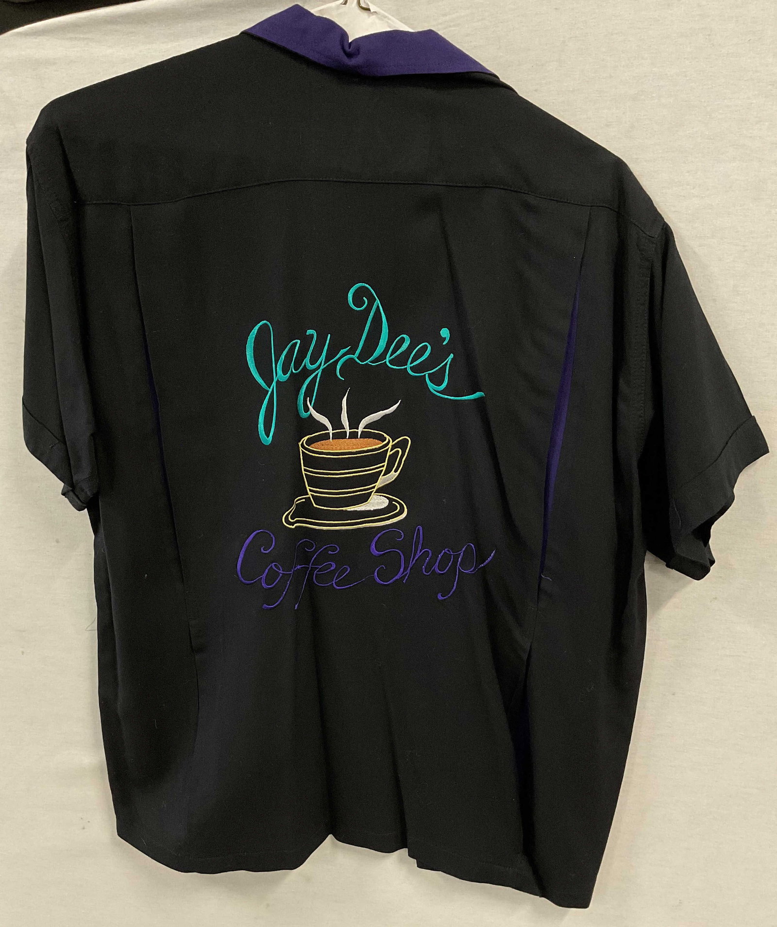 Bowld Over Embroidered Button Down Shirt: Bowld Over embroidered button down shirt. Size M. Rayon material. Black with purple accented collar. Buttons going top to bottom. Front pocket. Embroidered design on front reads Joe. On the back is an