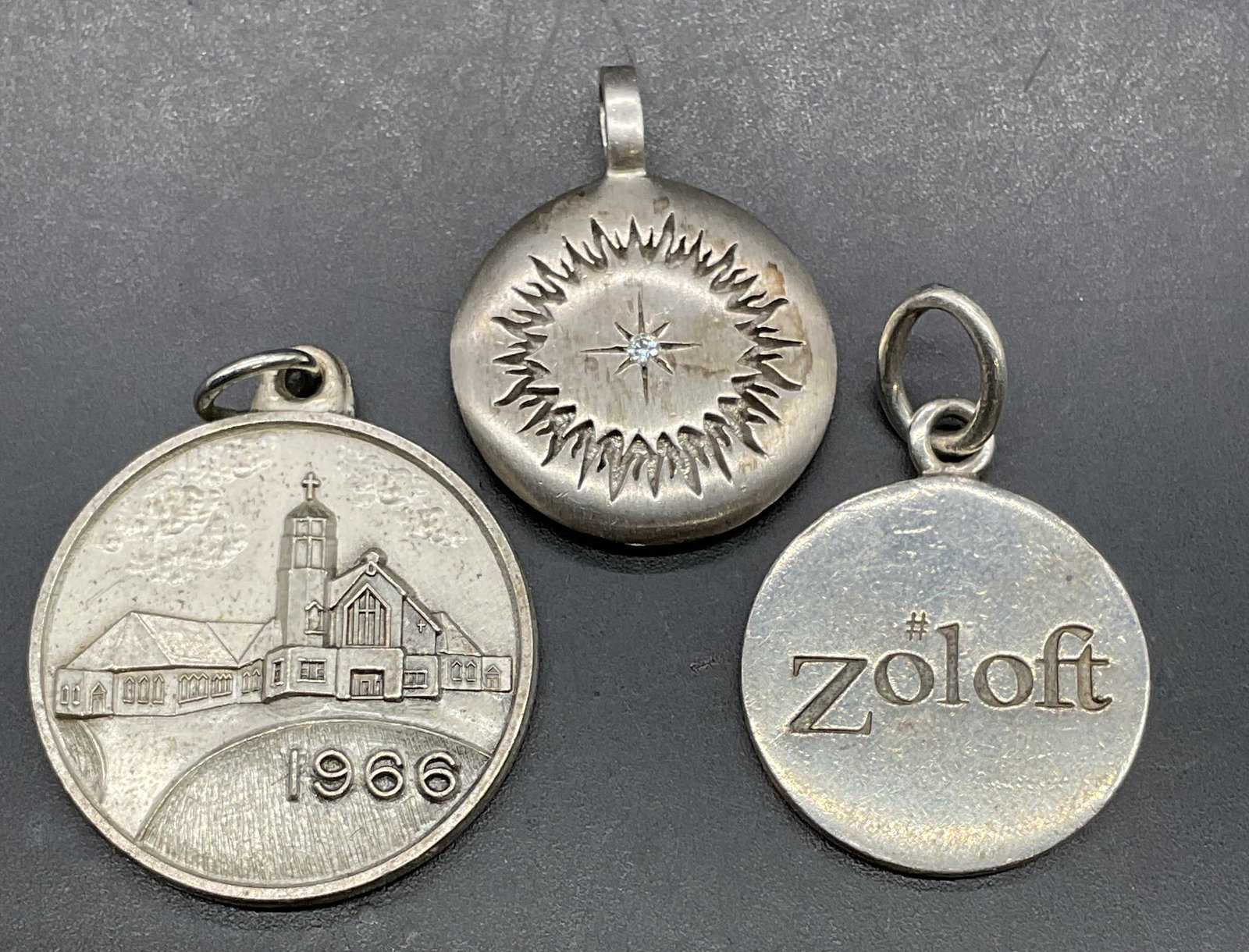 Lot 3 Sterling Silver Pendants, Zoloft+: Lot of 3 sterling silver pendants. Zoloft, St Pauls Church, and star motifs. Marked or tested for sterling using acid test. Largest approx 7/8 inches wide. Total weight of all 21.3 grams. Some scratch