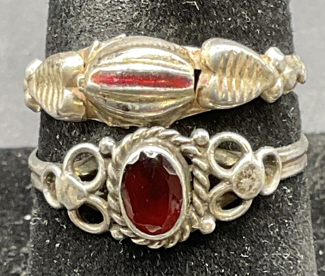 Lot 2 Sterling Silver Semiprecious Enamel Rings: Lot of 2 sterling silver rings. One with red semiprecious stone and one with red enamel. Larger ring size 8.5. Total weight of both rings 2.5 grams. Tests for sterling using acid test. Some scratching