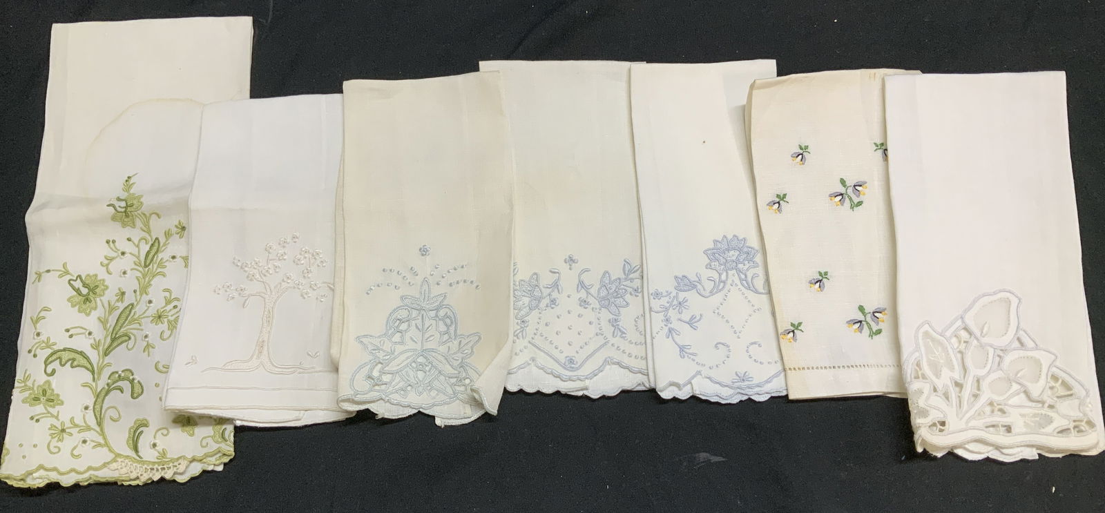Lot 7 Vntg Embroidered Linen Tea Towels: Lot includes, 7 vintage linen tea towels. Tea towels are white/cream toned & feature embroidered floral, tree motifs. Shades of green, grey, yellow, white & blue. 2 tea towels feature a cutwork style