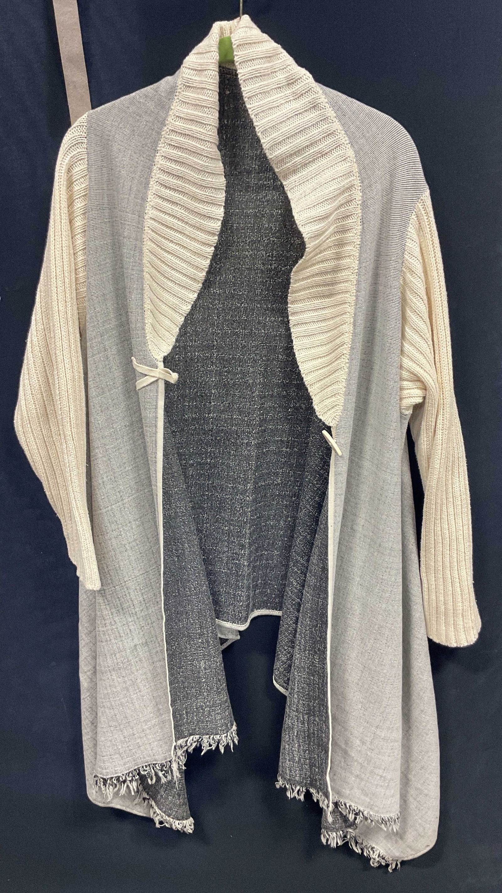 Iwanciw.com Grey Fringed Long Sleeve Shawl: Iwanciw.com grey fringed long sleeve shawl. Feels like cotton. Measures approx 26 inches across chest. Collared shawl. Collar and sleeves are white knit ribbed material. Variations of grey with black