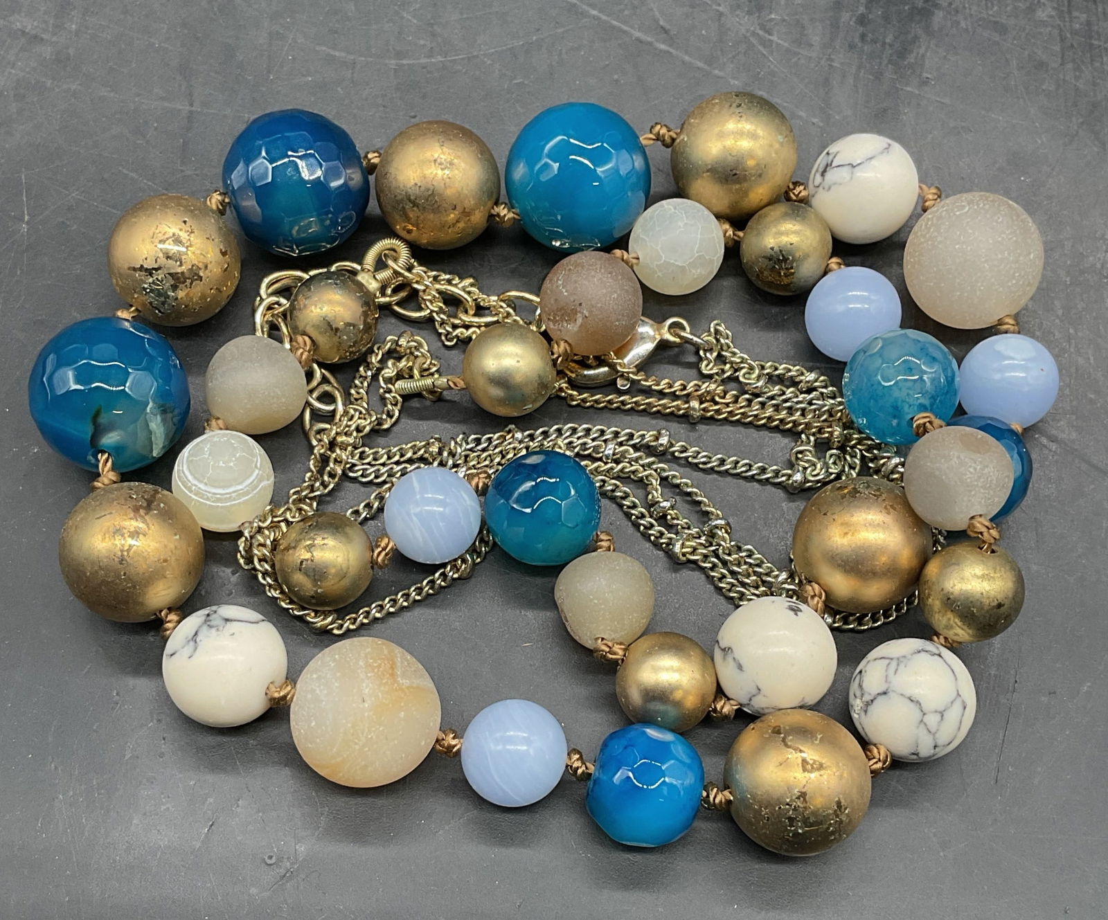 Signed Gold Tone Blue Stone Beaded Necklace: Signed T blue and white stone beaded necklace with gold tone accents. Drop length approx 18 inches. Some scratching. Jewelry, estate jewelry, costume jewelry, cocktail jewelry, fashion jewelry, access