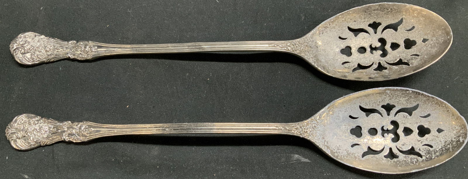 Set2 International Silver Company Serving Spoons: Lot includes, 2 international silver company serving spoons. Spoons feature an ornate & floral design on handle. Slotted pattern. Signed & marked on underside. Reads, INTERNATIONAL SILVER COMPANY. Sur