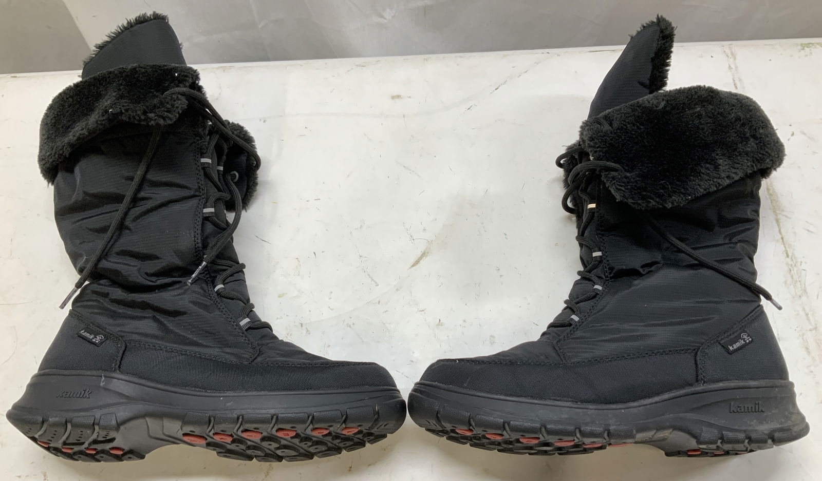 Pair Kamisk Bridefense Waterproof Boots: Waterproof boots are size 9. 100% faux fur polyester. Faux fur collar lining. Lace up closure & rubber lower section. Signed & marked. Reads, WATERPROOF IMPERMEABLE.. KAMISK. Surface wear consistent t