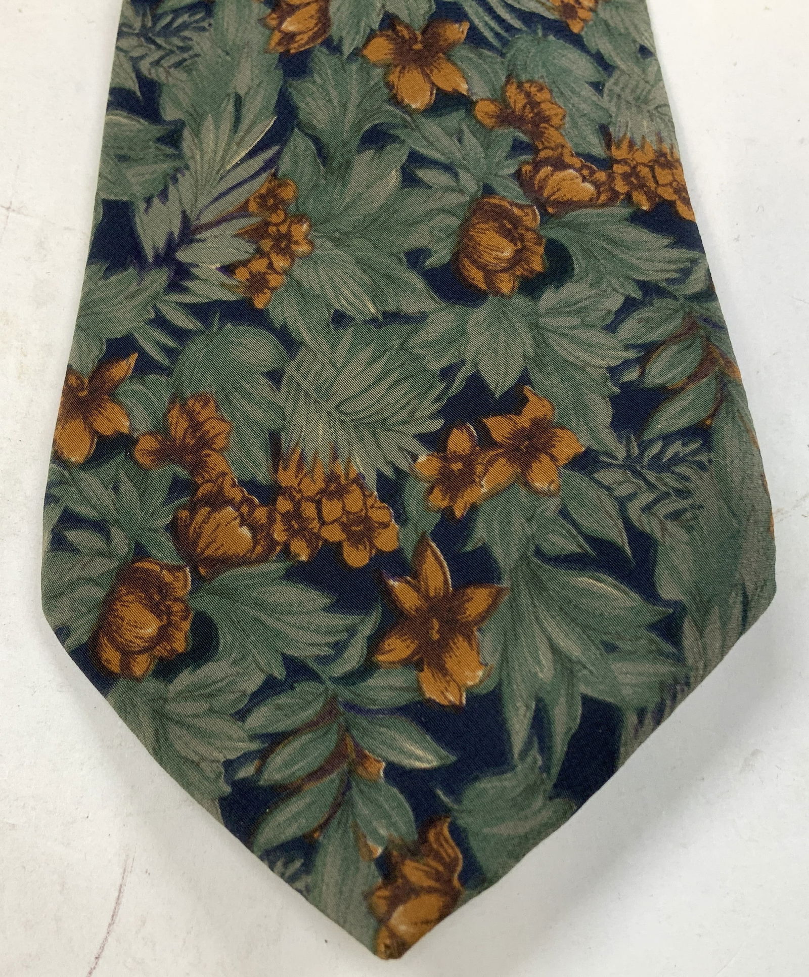 Fendi Green & Orange Floral Silk Necktie ITALY: Necktie is 100% silk & features a repeating pattern of green/orange floral motifs. Signed & marked on underside. Reads, FENDI. MADE IN ITALY. Surface wear consistent to age, use & exposure. Measuremen