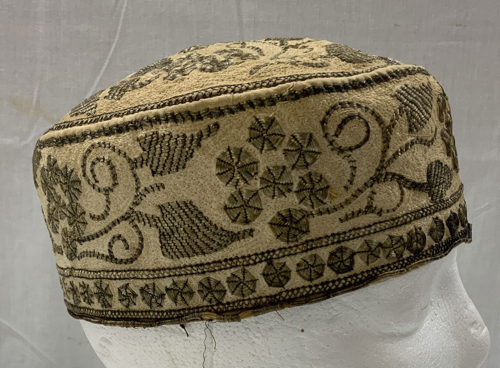 Vtg Hand Embroidered Cream Kufi Cap: Vintage hand embroidered kufi cap, in a cream color with gold metallic embroidery. Intricate circle & leaf like motifs. Appears to be cotton. No visible signature or markings. Surface wear consistent
