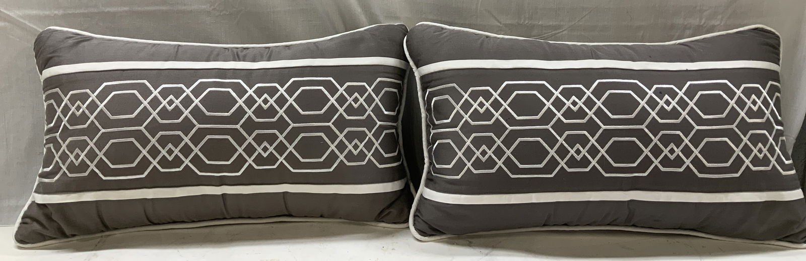 Pair Grey & White Geometric Embroid. Throw Pillows: Lot includes, pair of grey & white throw pillows featuring a geometric pattern embroidered across center of pillow. No visible signature or markings. Property of 69th Floor Hudson Yard Estate, Manhatt