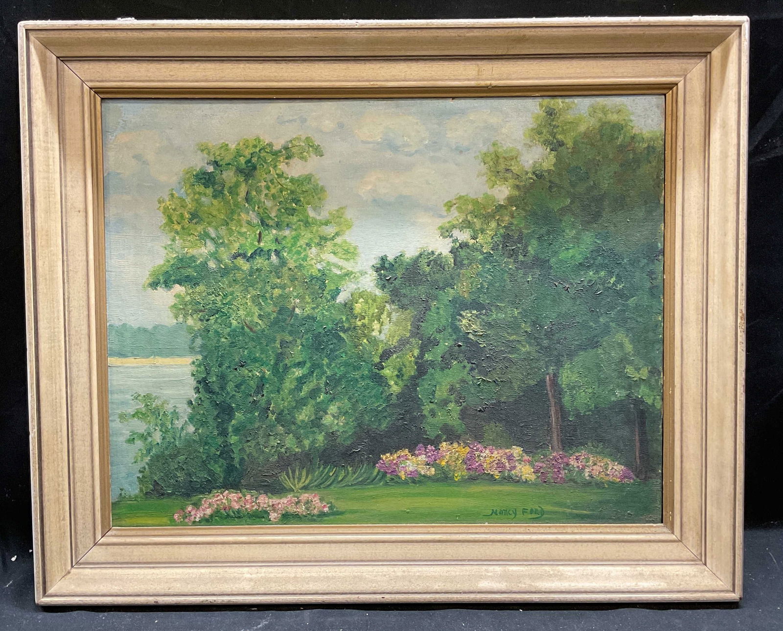 Signed Nancy Ford Landscape Oil Painting: Framed oil on board painting. Signed lower right, Nancy Ford. Landscape with view of flowers and trees. White wood frame. Not examined out of frame. Frame measures approx 17.75 x 21.75 inches. Some re