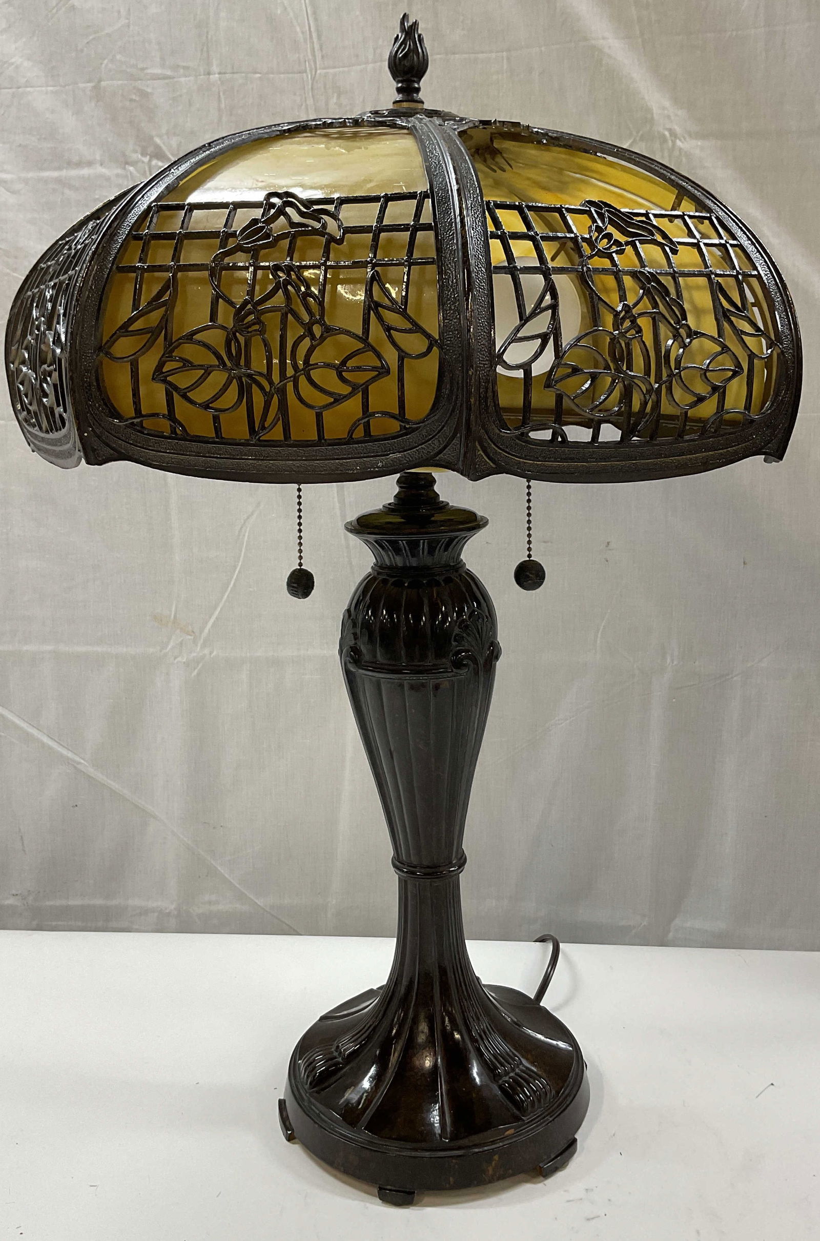 Dale Vintage Slag Glass Metal Table Lamp: Dale vintage slag glass metal table lamp. Marked on underside, reads Dale. Constructed with curved panels of slag glass in a yellowish tone. Metal shade has floral and shaped designs. Pointed finial.
