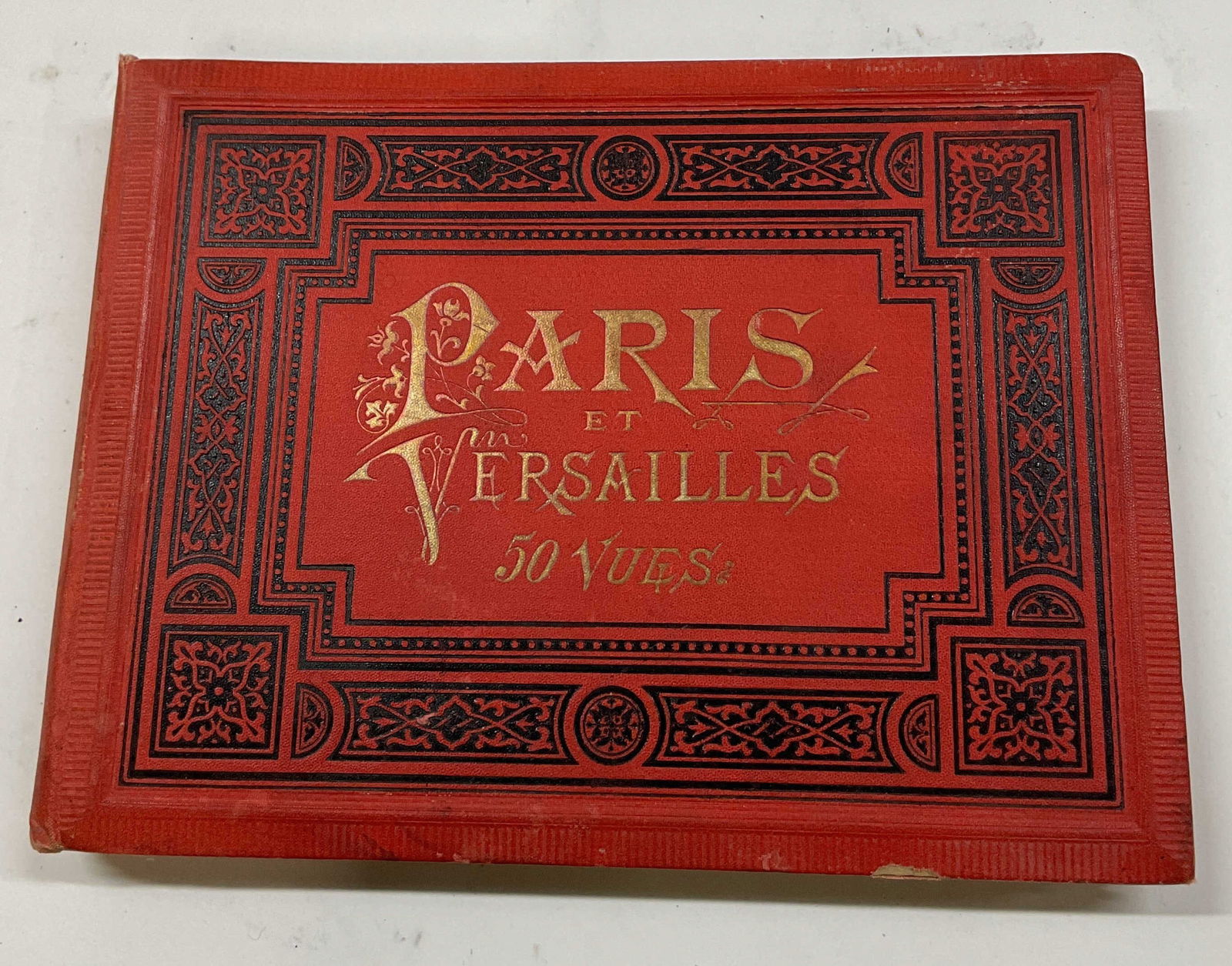 Antique Album Of Paris Postcards: Antique album of Paris postcards. Front cover reads as follows Paris Et Versailles 50 Vues. Red decorative album cover. Some include La Rue De Rivoli, La Place De La Republique, La Grande Cascade, and