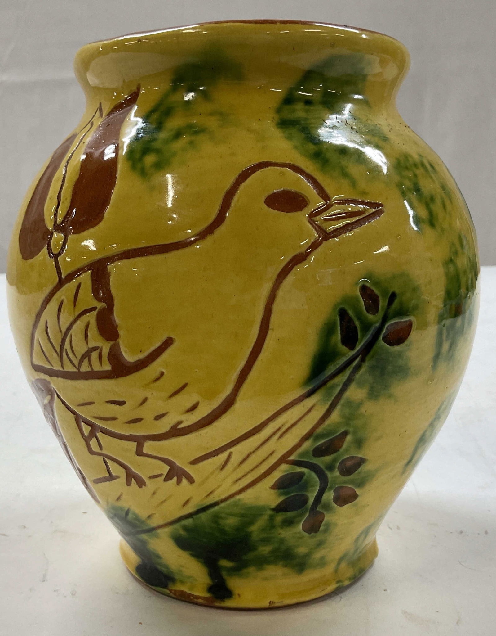 SGND Vintage Ceramic Bird & Floral Vase 1979: Vintage ceramic bird and floral vase. Signed on underside, reads illegibly. Dated 1979. Hand painted yellow background with green accents. Hand carved designs of bird and floral motifs in brown. Bulbo