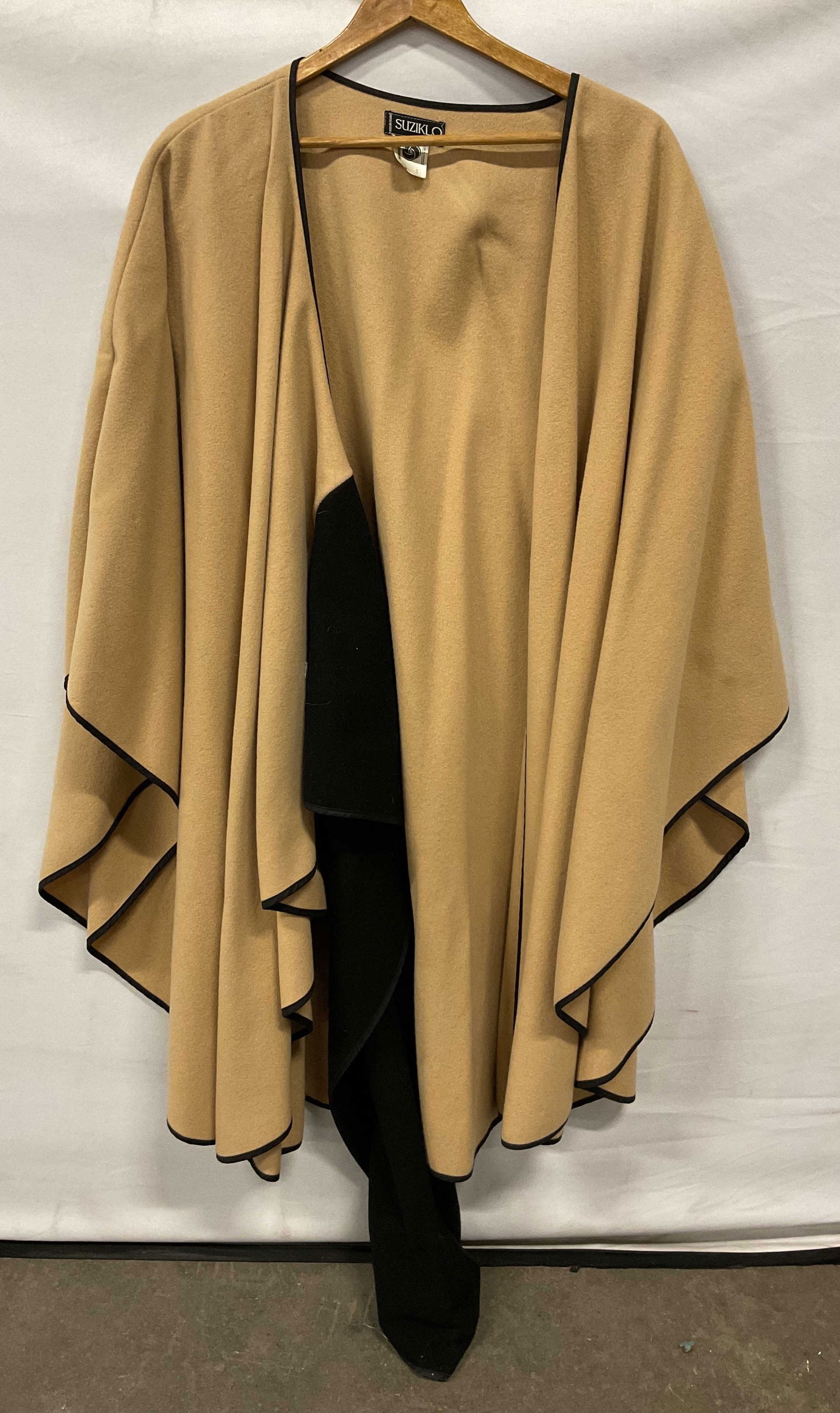 Suziklo Wool Beige & Black Shawl France: Suziklo wool beige and black shawl. Made in France. Wool material. Measures approx 42 inches across chest. Beige with accented black trim. Accented black flared design. Wear consistent with exposure.