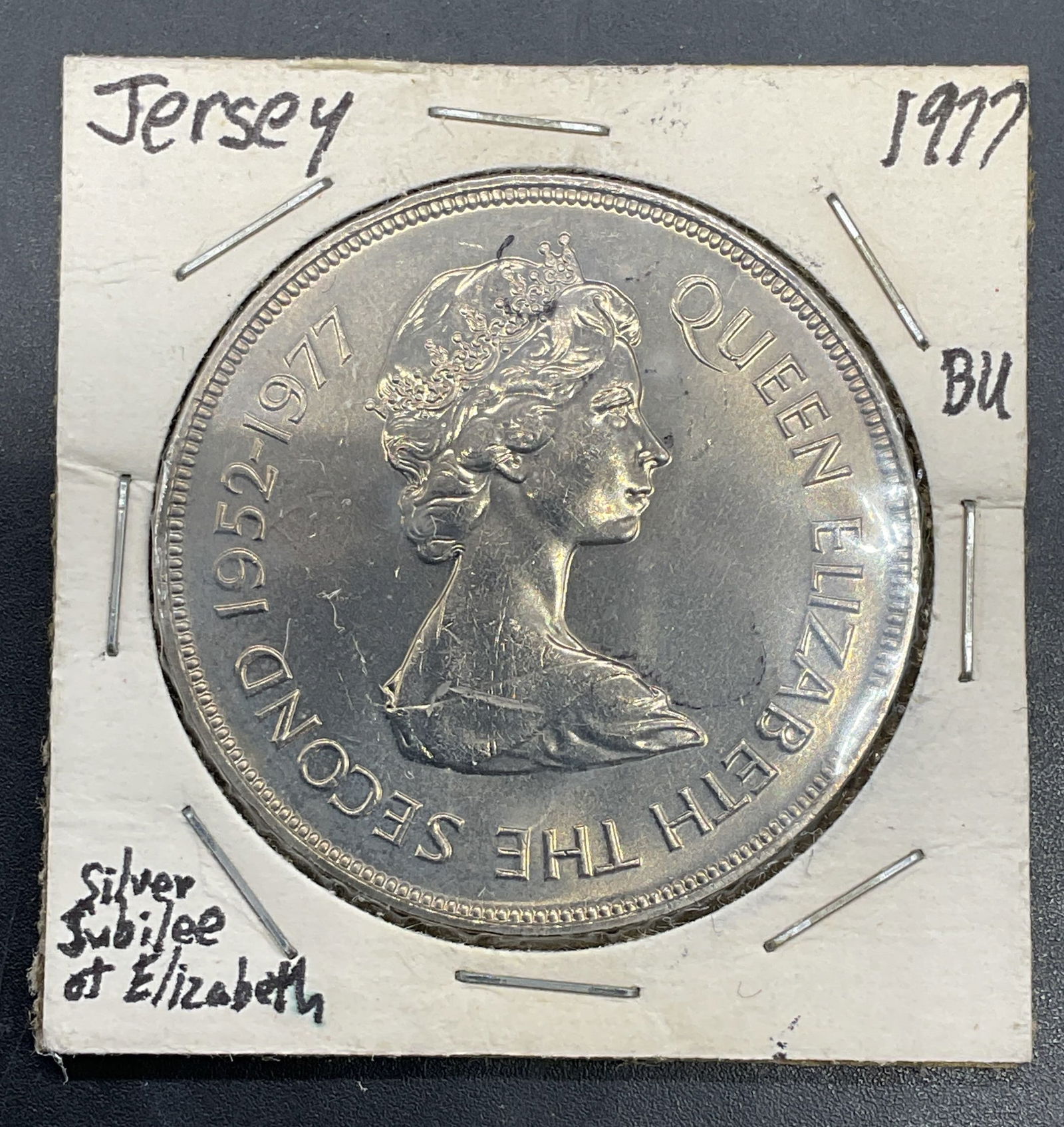 1977 Jersey Queen Elizabeth II Silver Jubilee Coin: 1977 Jersey 25 pence coin commemorating the Silver Jubilee of Queen Elizabeth II. Obverse features bast of Queen Elizabeth II, reverse features Gorey Harbour and Mont Orgueil. Copper nickel alloy. Mea