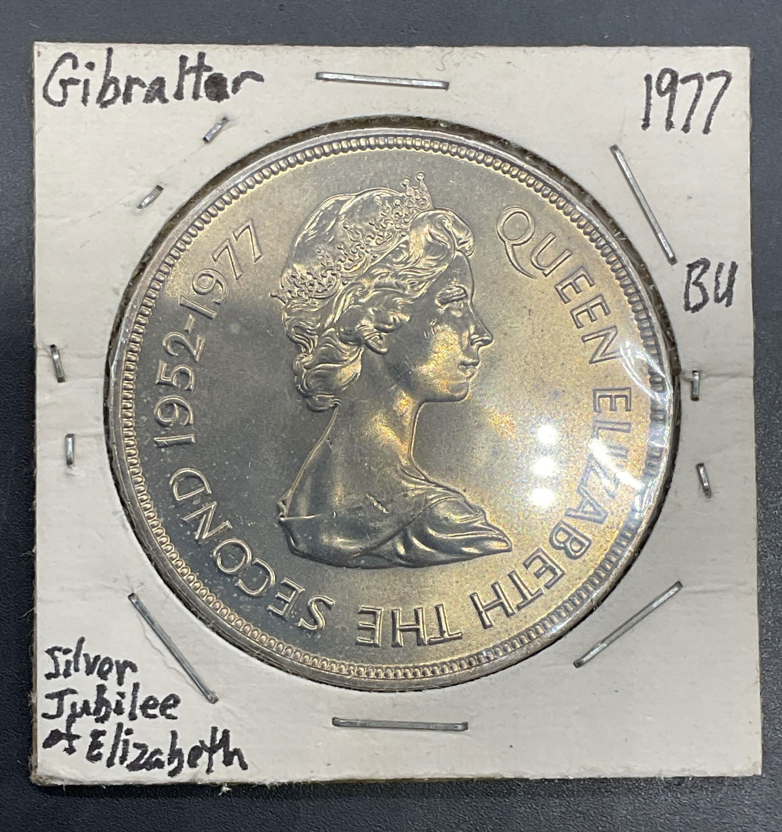 1977 Gibraltar Queen Elizabeth Silver Jubilee Coin: 1977 Gibraltar 25 pence coin commemorating the Silver jubilee of Queen Elizabeth II. Obverse with bust of Queen Elizabeth II, reverse with shield and castle. Copper nickel alloy. Measures approx 1.5 i