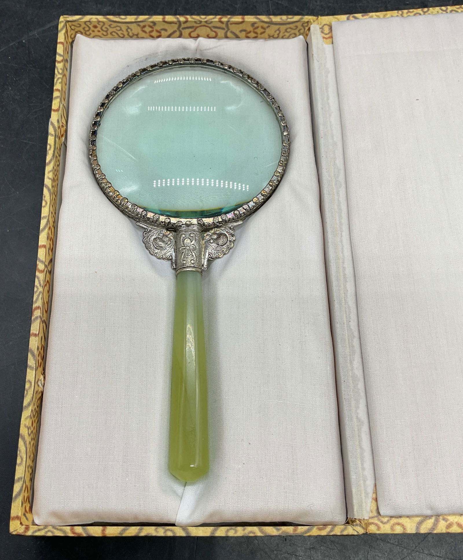 Chinese Celadon Jade Handle Magnifying Glass w Box: Vintage Chinese decorative magnifying glass. Celadon jade handle with ornate metal frame. Measures approx 7 x 3.25 inches. Includes display storage box with fitted cushioned interior. Some wear consis