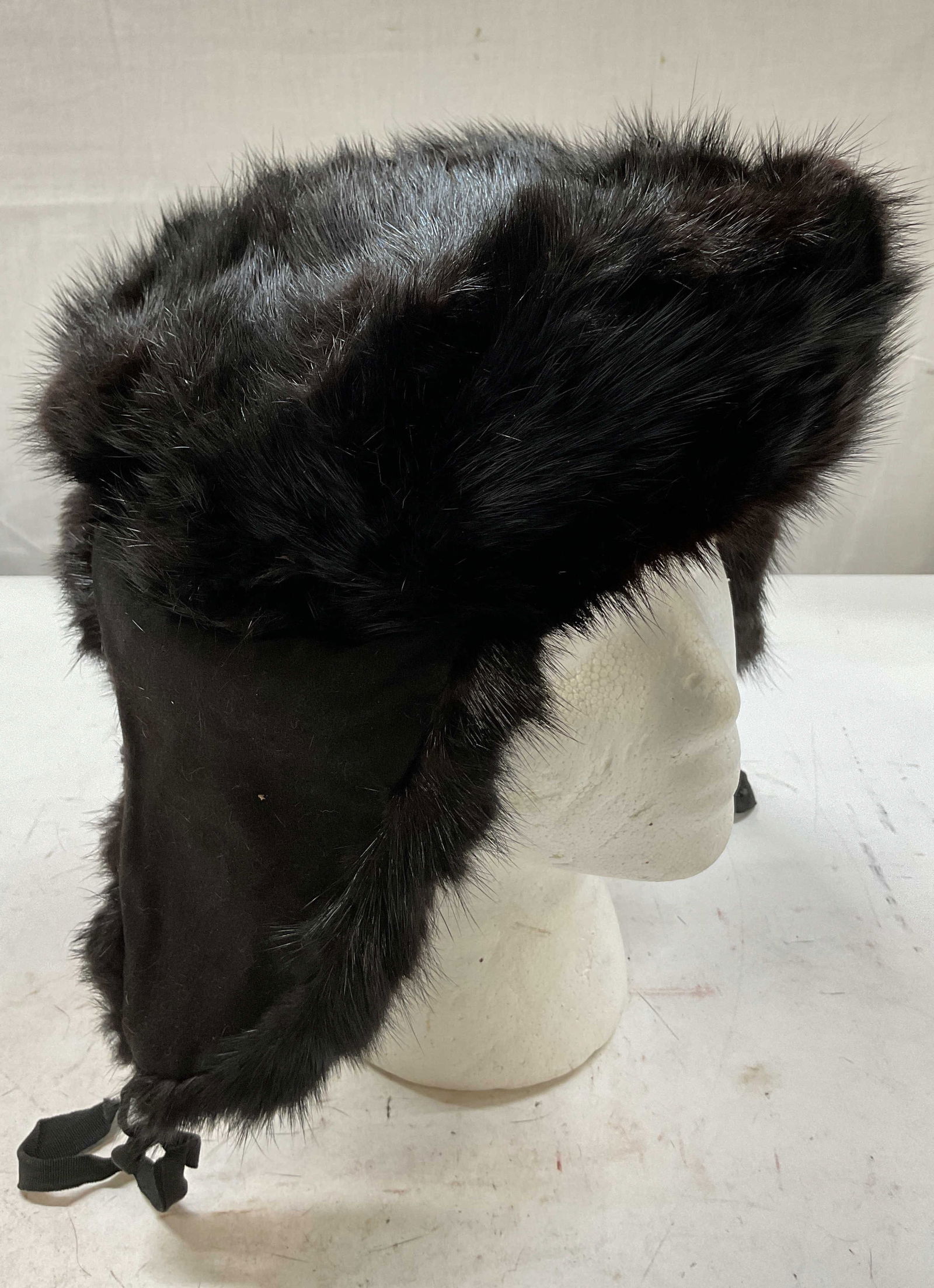 Saks Fifth Avenue Mink Fur Hat W Ear Flaps Canada: Saks Fifth Avenue black mink fur hat. Has ear flaps that can be worn up or down. Circular shape. Tag reads Dyed Muskrat Sides Fur Origin Canada. Measures approx 11 inches in diameter. Head circumferen