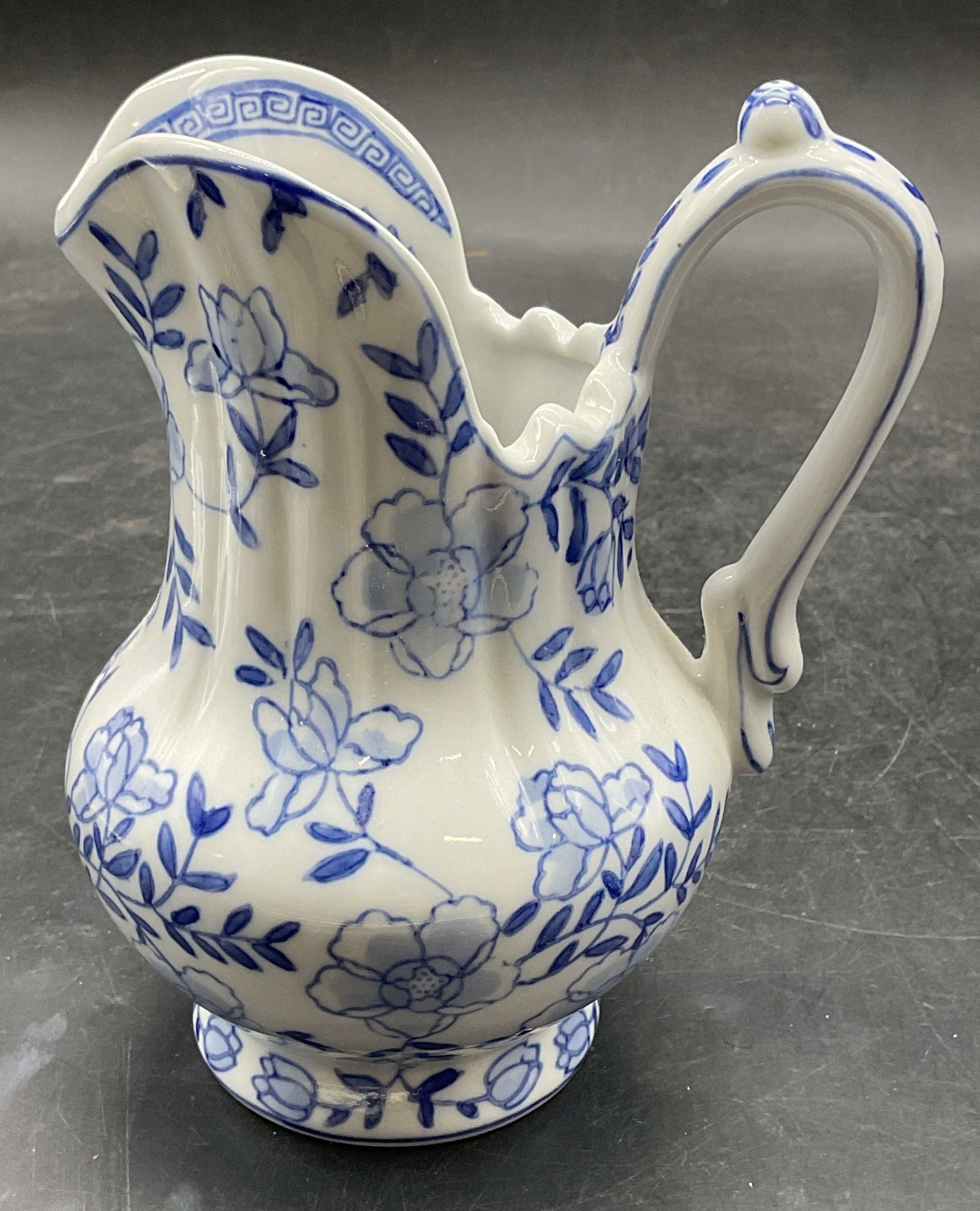Andrea by Sadek Blue & White Porcelain Creamer: Signed Andrea by Sadek porcelain creamer. Hand painted blue and white with floral design. Measures approx 4 x 3.5 x 5.75 inches. Some scratching. Andrea by Sadek creamer, porcelain creamer, floral