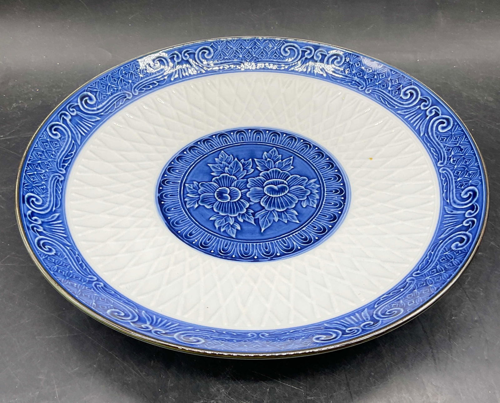 Signed Blue & White Porcelain Peony Plate, Japan: Signed porcelain plate. Hand painted blue and white with peony design. Signed on underside. Made in Japan. Measures approx 10.75 x 1.75 inches. Some wear consistent with exposure. Japanese plate,