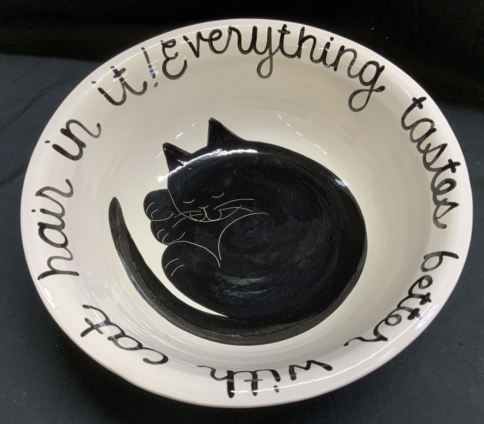 Sgnd Everything Taste Better W Cat Hair Srving Bwl: Serving bowl is ceramic & features a black/white cat design in the center. Rim of bowl reads, Everything Tastes Better with Cat Hair In It. Signed & marked on underside. Reads, L. Veasey. Surface wear