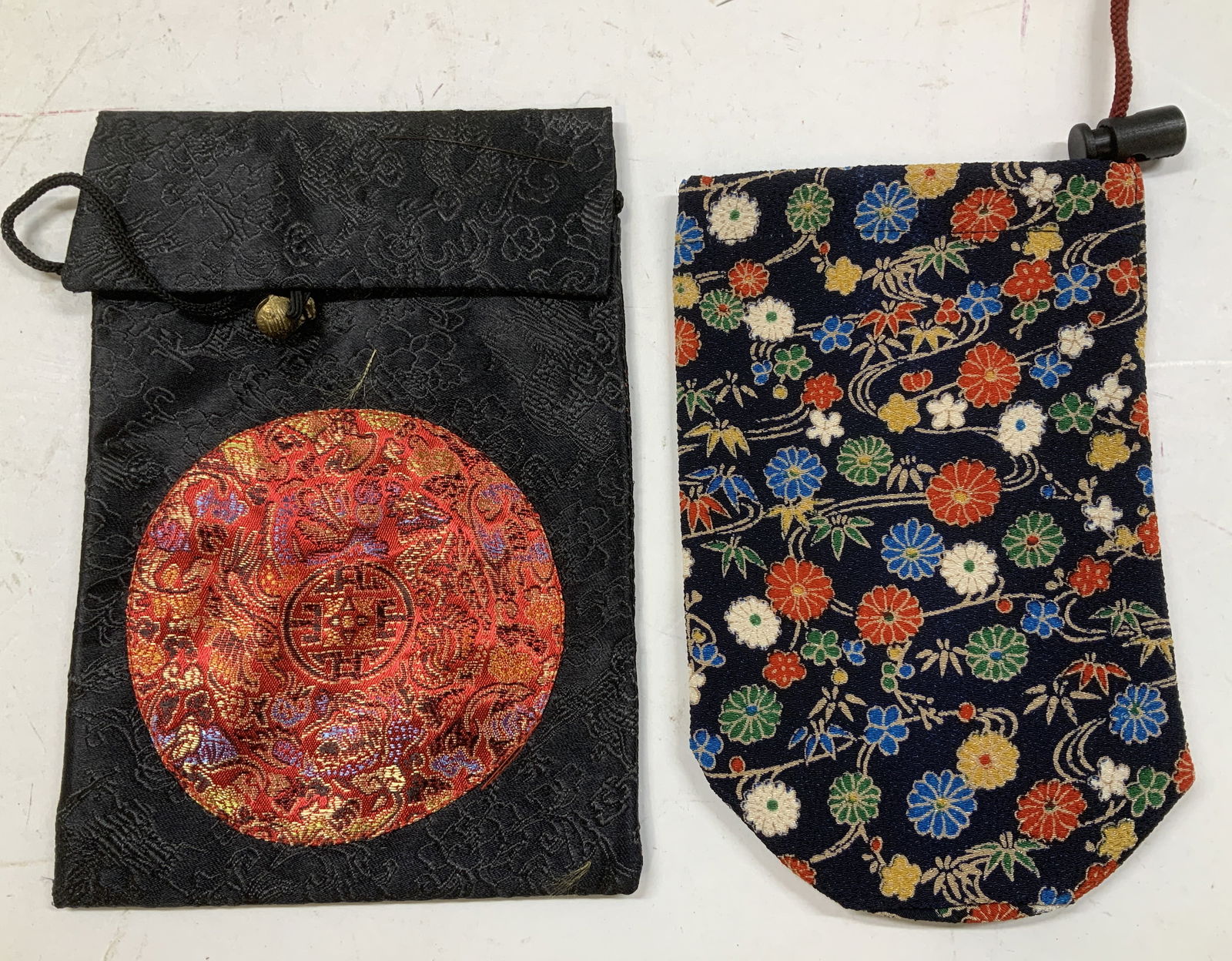 Lot 2 Silk Crossbody Bag & Insulated Bottle Cooler: Lot includes 1 black & red silk crossbody bag with bell accent & cord strap. Also includes, bottle cooler/holder. Features floral motifs. Surface wear consistent to age, use & exposure.