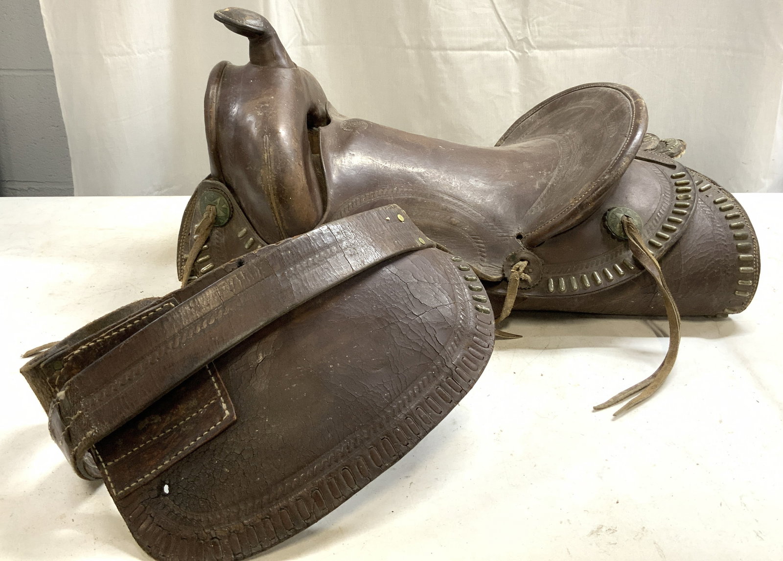 RANGE KING Western Concho Saddle & Wooden Stirrups: RANGE KING Western Concho Saddle & Wooden Stirrups Lot includes 1 wooden w metal stirrups, 1 western saddle. Horse saddle is dark brown toned & leather. Piece has numerous, small, elongated metal plac