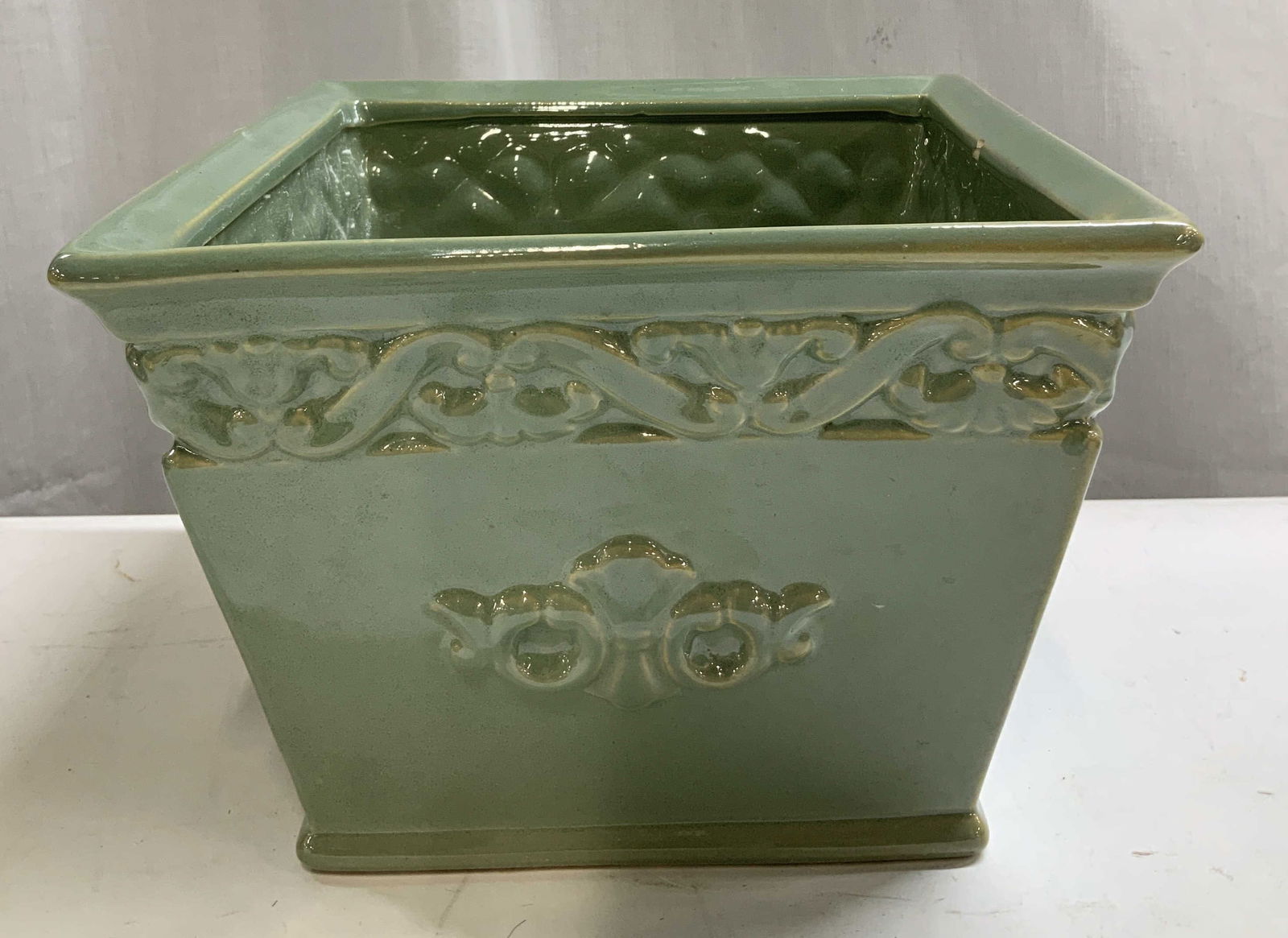B Green Glazed Ornate Ceramic Planter: Planter is ceramic material & features raised ornate detailing. Green glazed glossy finish. Surface wear consistent to age, use & exposure. Signed & marked on underside. Reads, B. Measurements: length