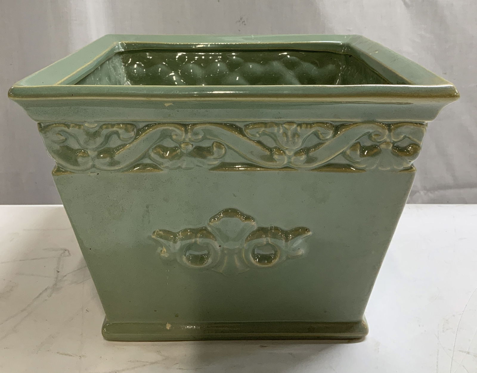 Green Glazed Raised Ornate Ceramic Planter: Planter is ceramic material & features raised ornate detailing. Green glazed glossy finish. Surface wear consistent to age, use & exposure. Measurements: length 8.4in x width 8.4in x height 6in. Green