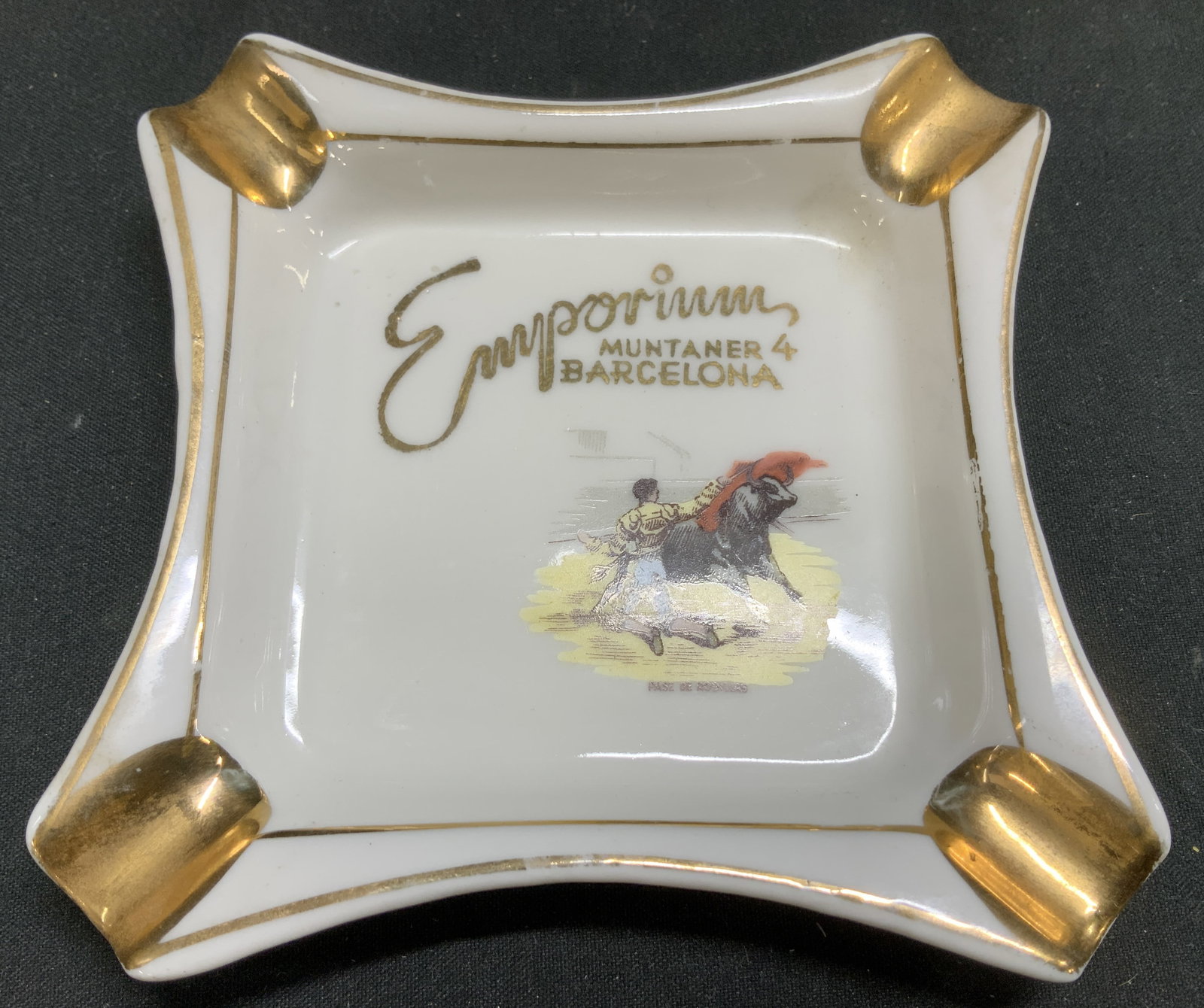 Emporium Muntaner 4 Barcelona Porc Ashtray: Porcelain ashtray featuring a bullfighting scene with text that reads, Emporium MUNTANER 4 BARCELONA & PASE DE RODILLAS. Curved gilt sides. Property of Upper East Side French stage and screen actors E
