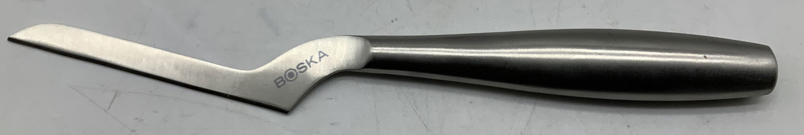 Boska Copenhagen Stainless Steel Cheese Knife: Cheese knife is stainless steel material & is designed for soft cheeses like Brie and Mozzarella. Narrow blade. Signed & marked. Reads, BOSKA. COPENHAGEN FOR BRIE & MOZZARELLA. NO.1 of 3. Surface