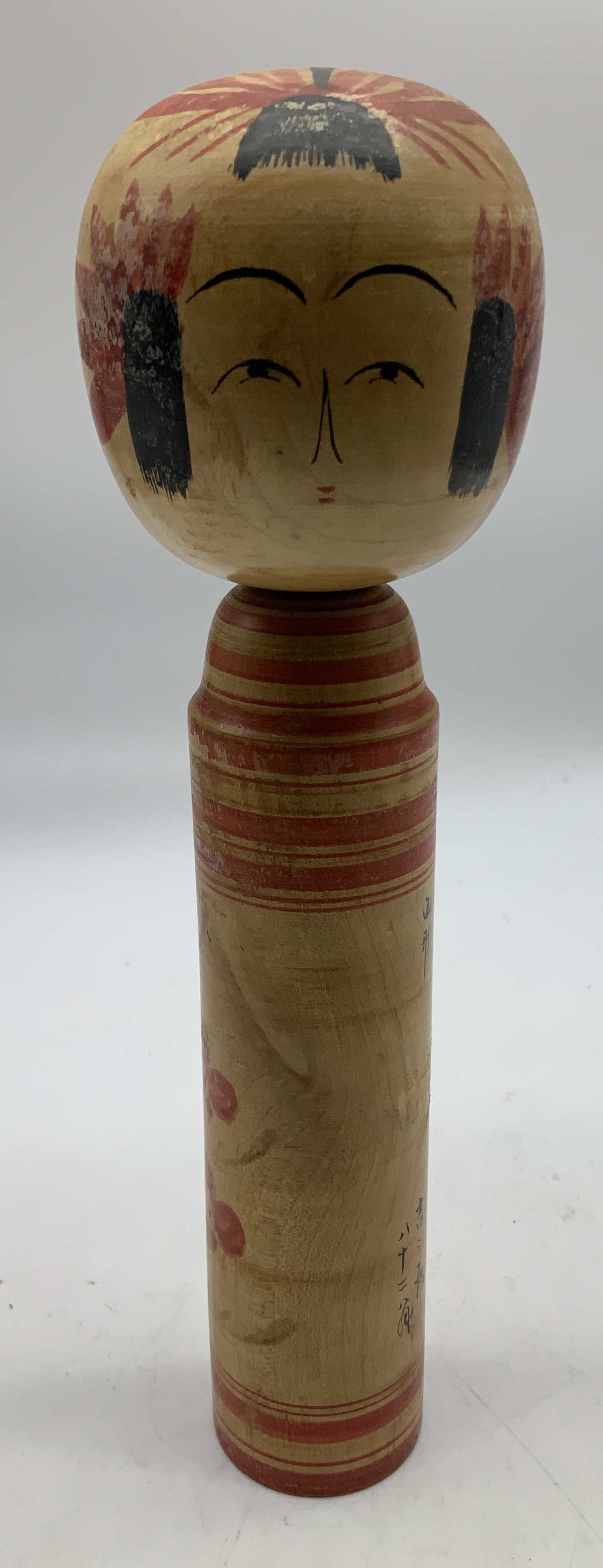Sgnd Traditional Japanese Kokeshi Wooden Doll: Traditional Japanese Kokeshi doll. Doll is wooden material w hand painted red floral motifs & facial accents. No arms & legs. Signed & marked. Visible Japanese lettering on body. Surface wear