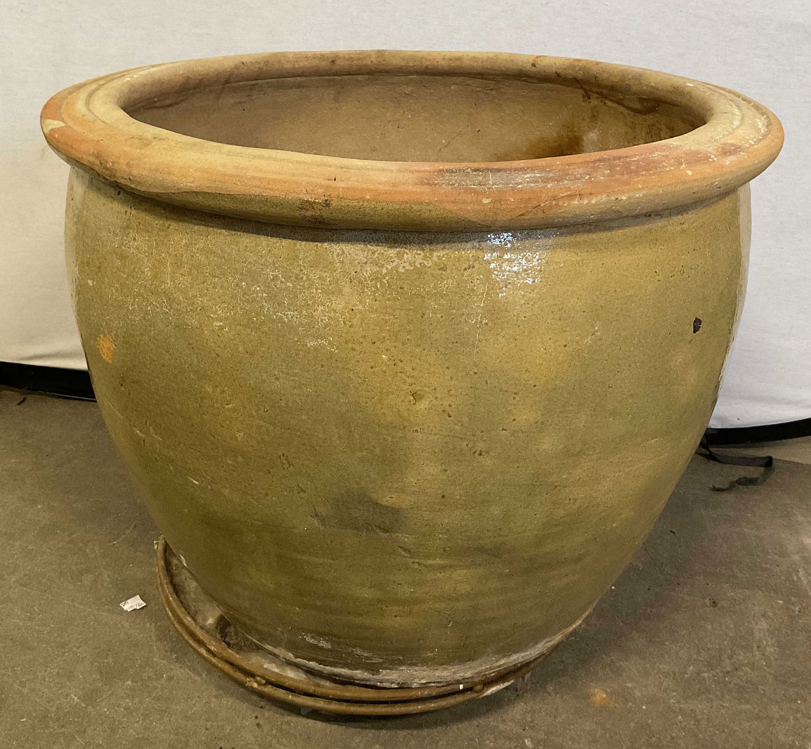 Vintage Large Ceramic Planter: Vintage large ceramic planter. Soft yellow color. Classic round shape with wide body that tapers towards the base. Glazed finish. Rolled rim. Sits on round flat base with wheels. Measures ht approx 21