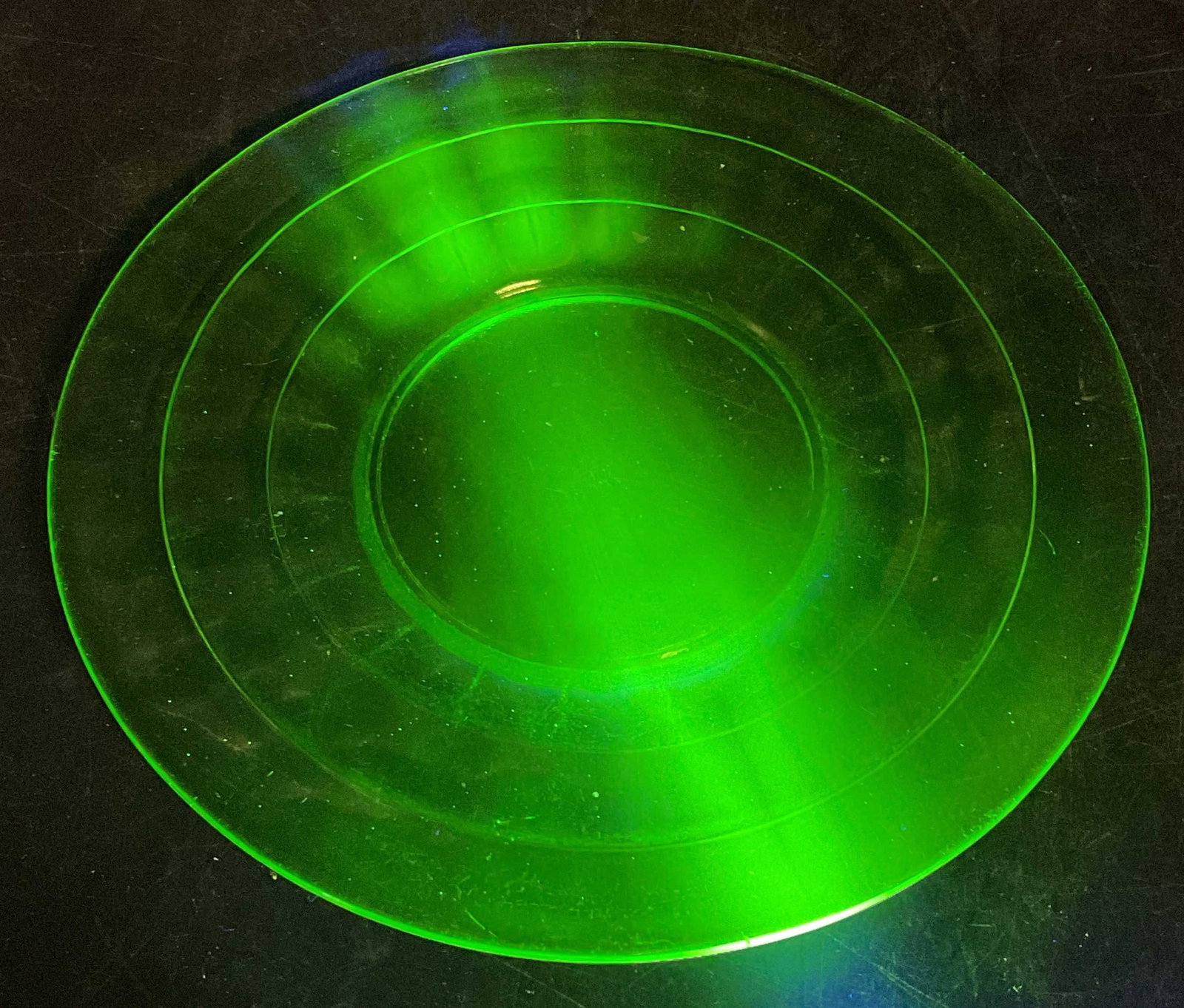 Vintage Green Uranium Glass Plate: Vintage uranium glass plate with circle pattern. Measure approx 6.25 inches wide. Glass is UV light reactive. Some scratching. Uranium glass, uranium glass plate, vintage uranium glass, collectibles,
