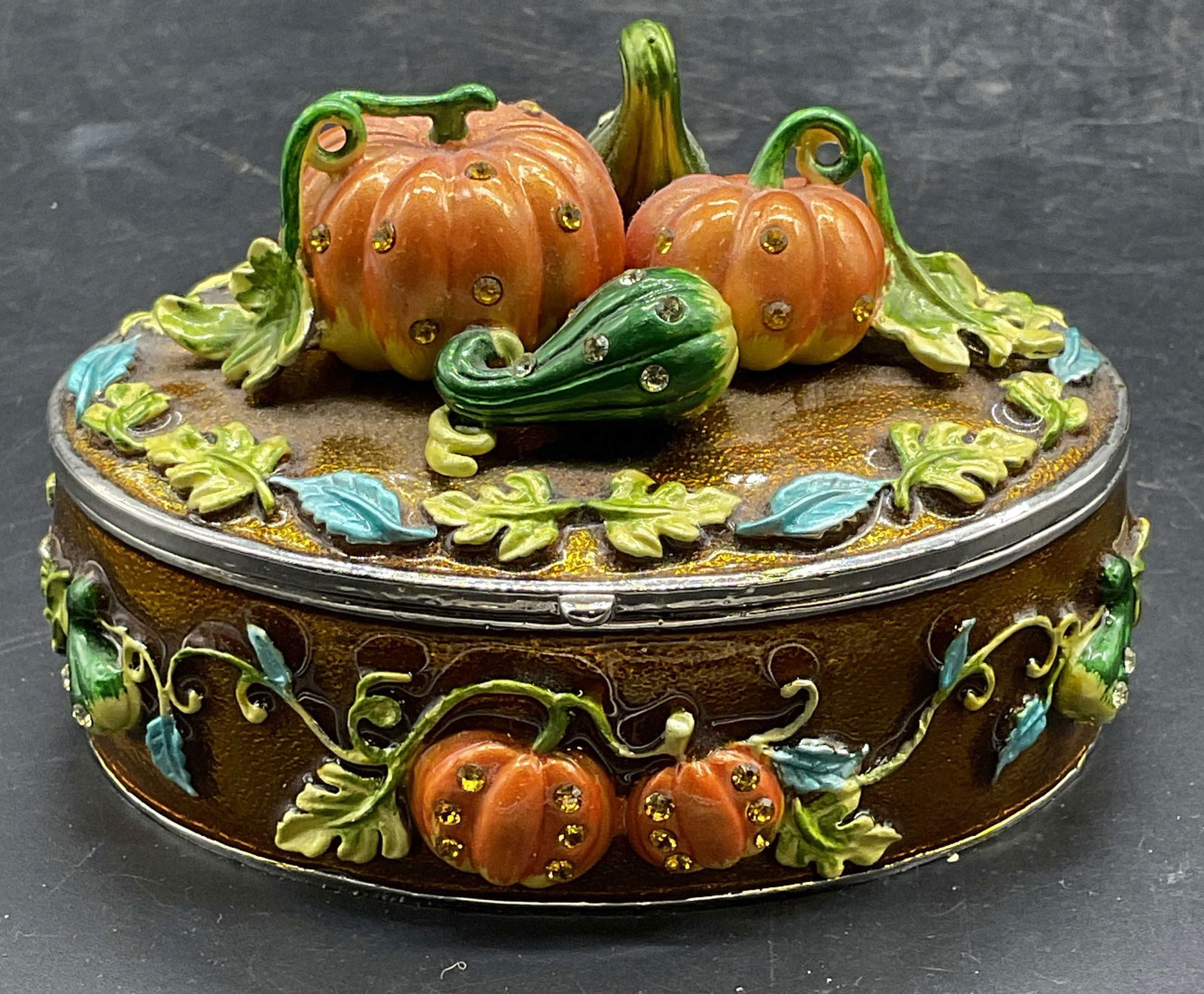 Rucini Enameled Crystal Pumpkin Trinket Box: Signed Rucini Enameled metal trinket box with crystal decoration. Pumpkin and gourd final. Gold tone with blue and green accents. Measures approx 3.5 x 2.5 inches. Some wear consistent with