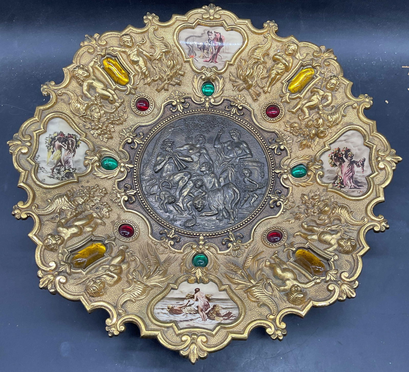 Antique Gilt Bronze Classical Medallion Plate: Antique Italian style gilt bronze medallion plate with classical motifs. Raised putti and ornate scroll designs with inlaid glass cabochons and figural panels. Measures approx 17 inches wide.