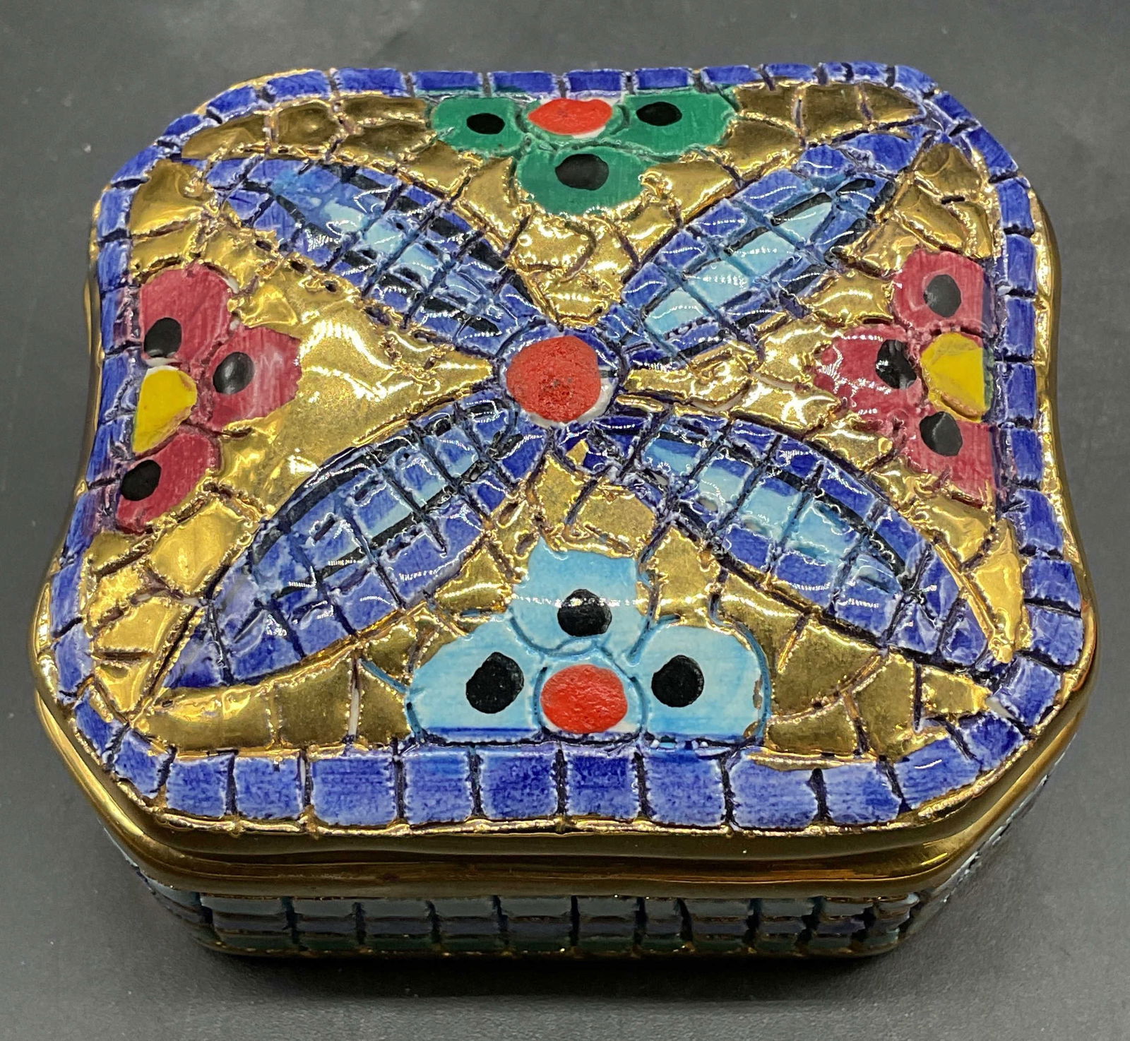 Ravenna Gilt Blue Ceramic Trinket Box: Signed Ravenna hand painted and gilt ceramic trinket box. Floral design in blue, pink, and green. Measures approx 2.75 x 2.25 x 1.5 inches. Some wear consistent with exposure. Ravenna trinket box,