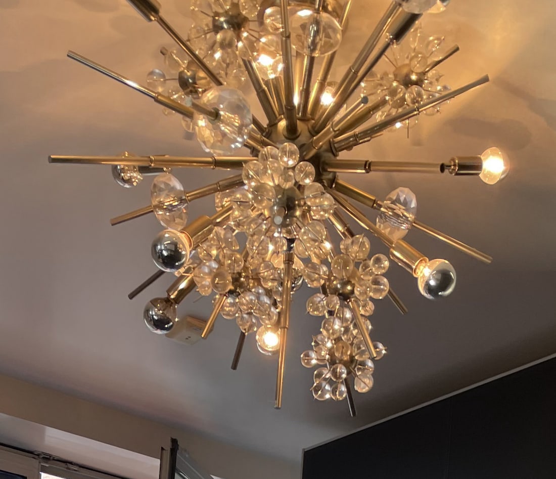 Sputnik Mid Century Modern Style Chandelier: A Sputnik mid century modern style chandelier. Crafted from metal and colorless spheres. Some spheres are faceted. Measures approx. 19 inches in height and 22 inches in width, measured in box. Weighty