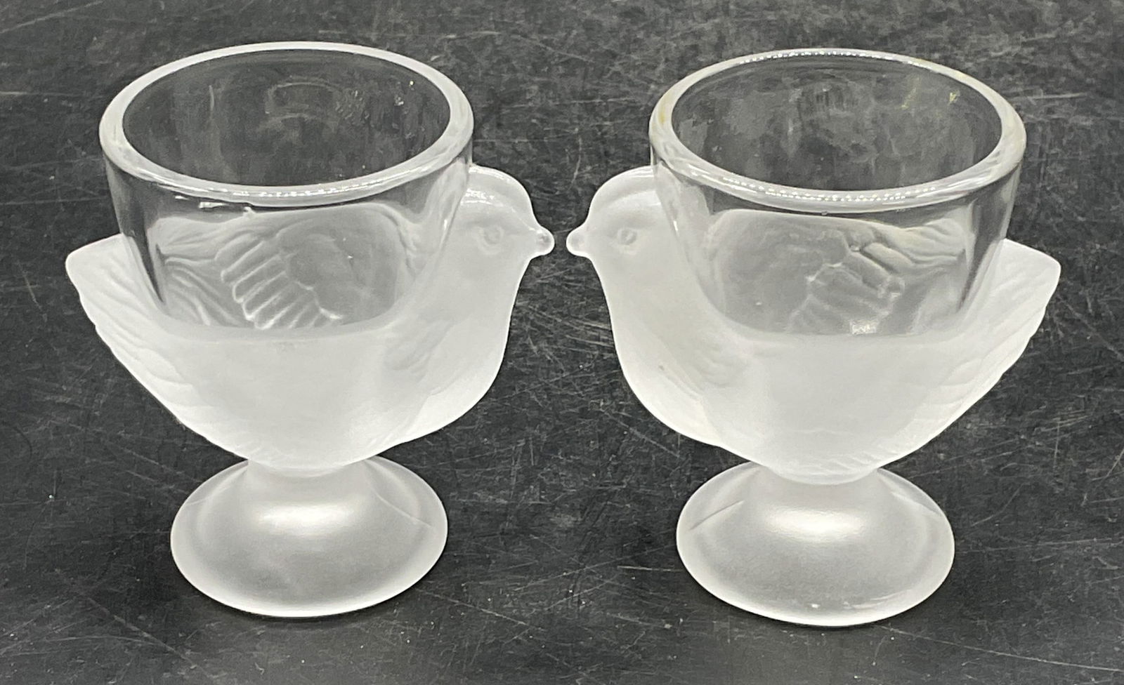 Pair Frosted Glass Bird Egg Cups, France: Pair of frosted glass bird motif egg cups. Made in France. Measure approx 2.5 x 2.75 inches. Some wear consistent with exposure. Egg cups, bird egg cups, frosted glass egg cups, tableware, table acces