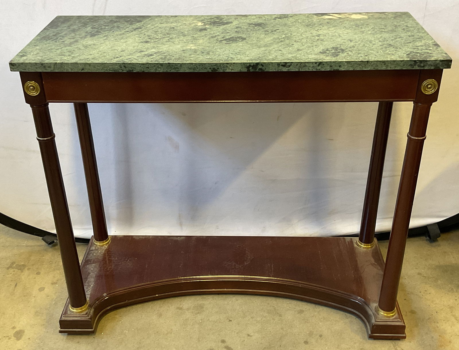 Bombay Neoclassical Mahogany Marble Console Table: Bombay Company mahogany and green marble neoclassical empire style console table. Decorative brass hardware. Measures approx 34.75 x 14 x 30.25 inches. No visible signature. Some scratching,