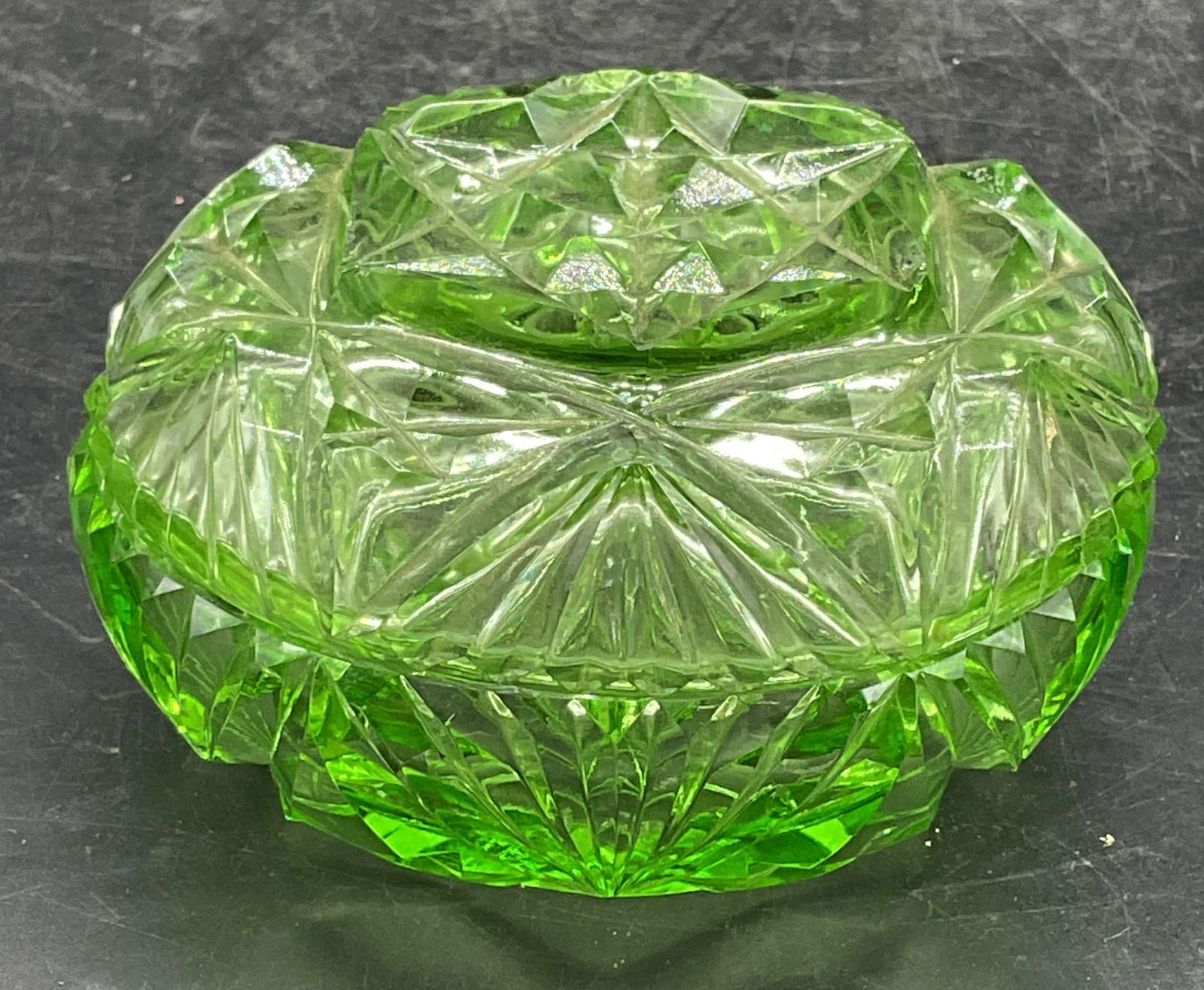 Vintage Uranium Cut Glass Lidded Trinket Dish: Vintage uranium glass lidded trinket dish. Round shaped box with cut star design. Measures approx 3.75 x 2.25 inches. Made in Czechoslovakia. Glass is UV light reactive. Some scratching. Uranium
