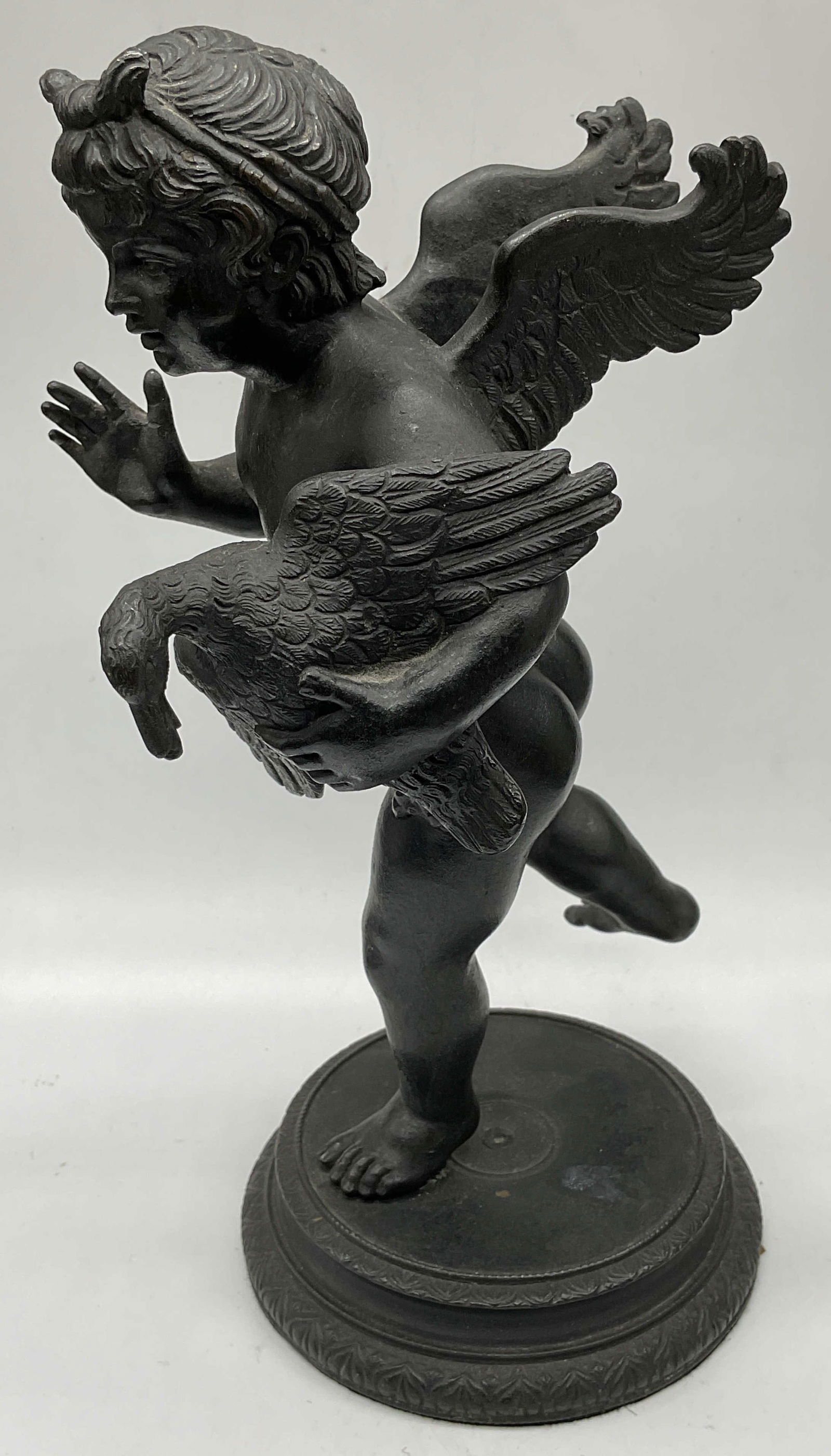 Cupid With Goose Cast Metal Statue: Cast bronze patina metal statue depicting Cupid with a goose. Measures approx 5.5 x 4.5 x 9.25 inches. Wear including scratching. Cupid with goose, classical style statue, Cupid statue, cherub statue,