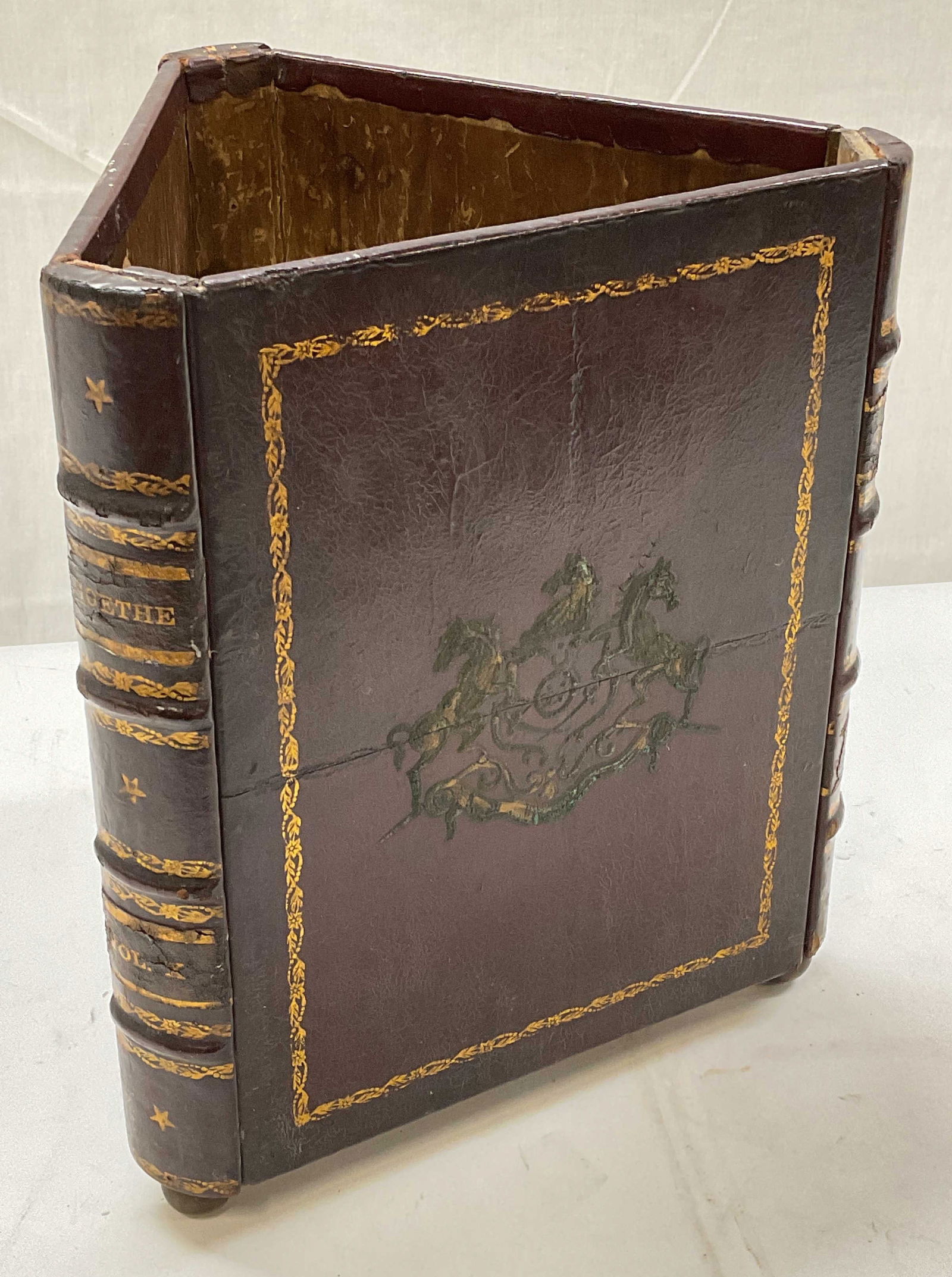 Vtg False Book Leather & Wood Waste Basket: Vintage false book motif waste basket. Leather covered wood with ball footed base. Ornate horse and scroll design with spines that read Goethe. Gilt decoration. Measures approx 11.5 x 10 x 13.5 inches