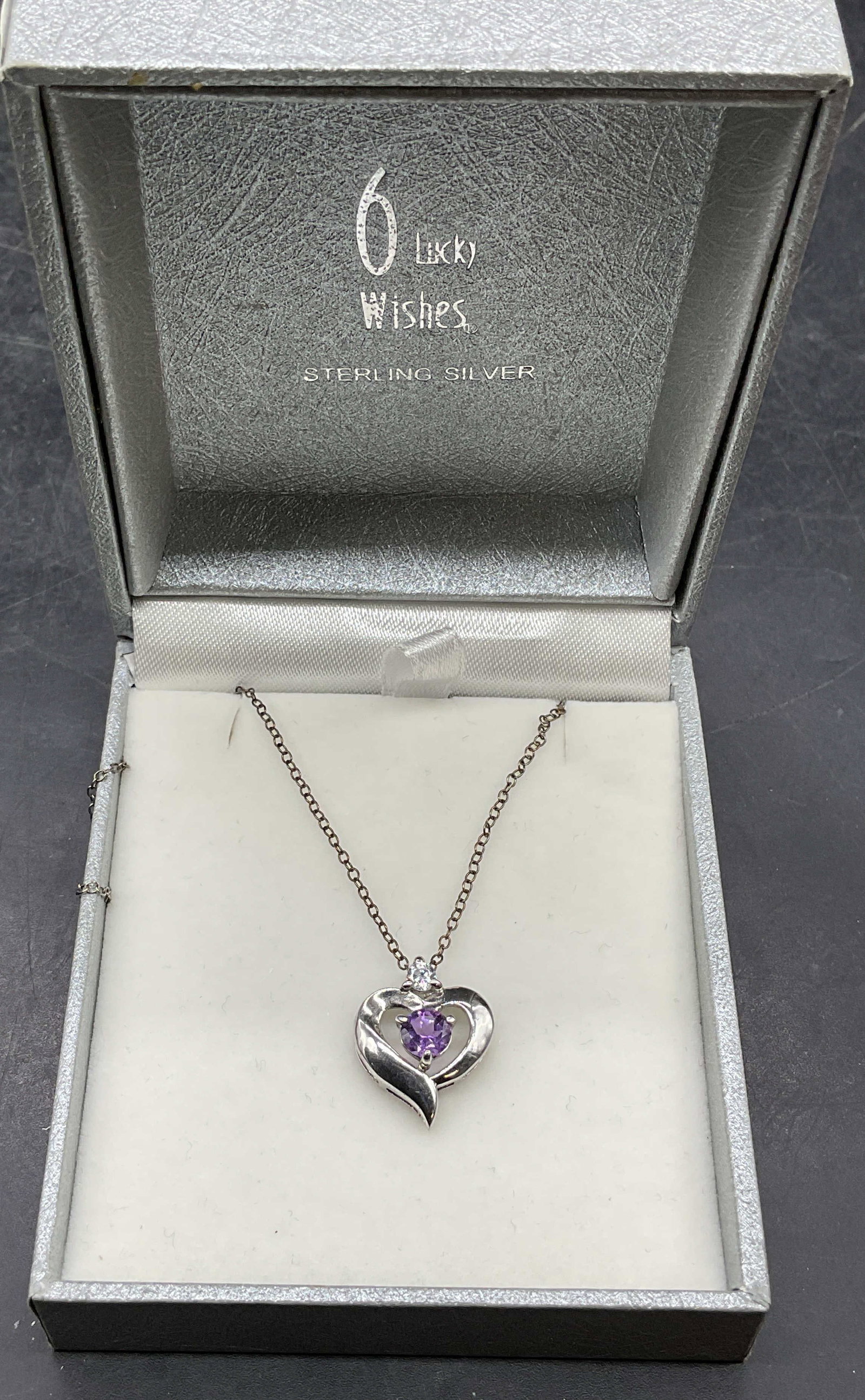 HAN Sterling Silver Semiprecious Heart Necklace: Signed HAN sterling silver necklace with heart pendant and purple and colorless semiprecious stones. Drop length approx 9 inches. Total weight 2.5 grams. Marked sterling. Includes a box. Some scratchi