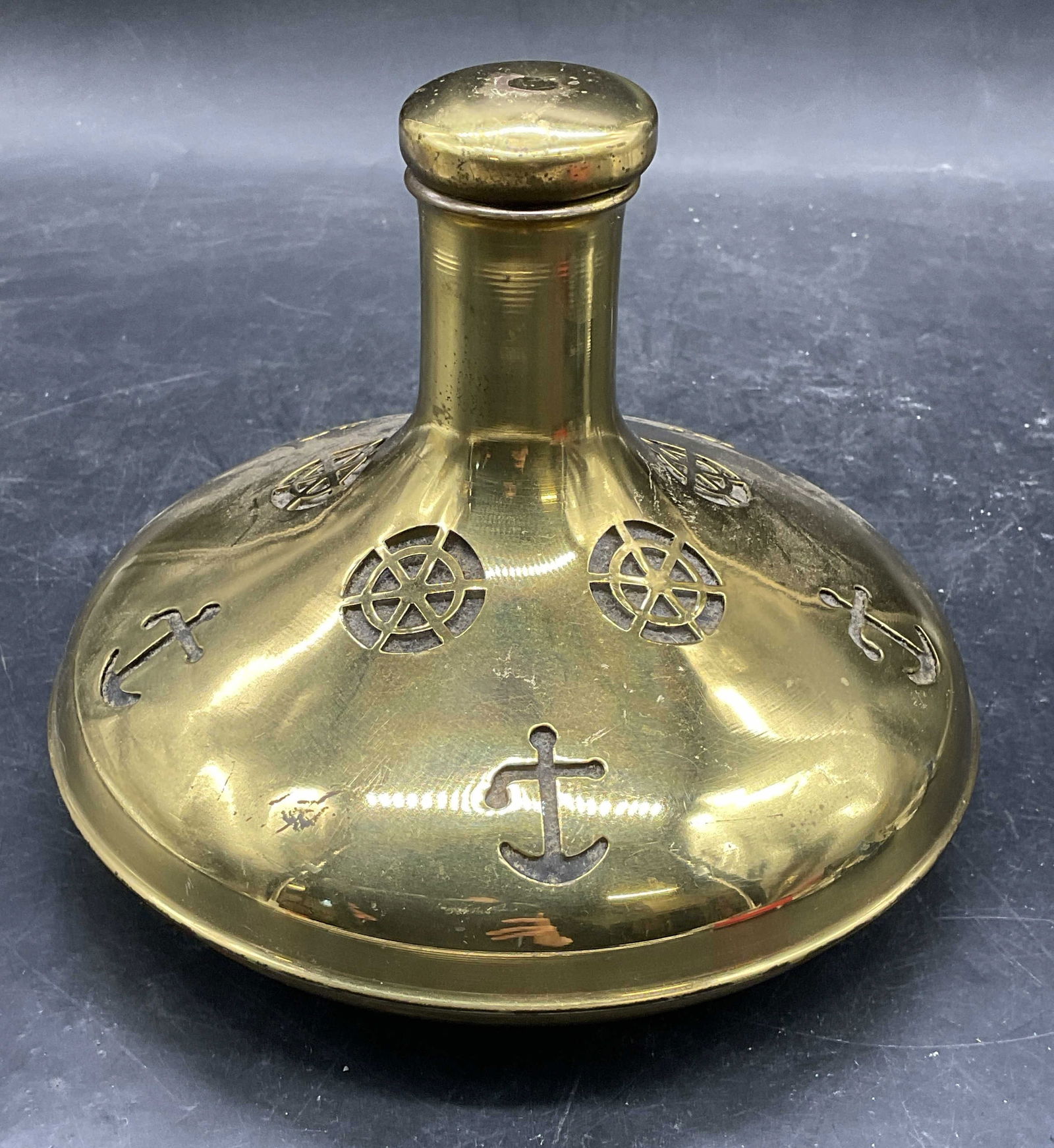 Brass & Glass Nautical Ships Decanter, Sweden: Brass covered glass ships decanter. Cutout nautical motifs, anchor and ships wheel. Made in Sweden. Measures approx 6.5 x 5.5 inches. Wear including scratching and patina. Ships decanter, nautical dec