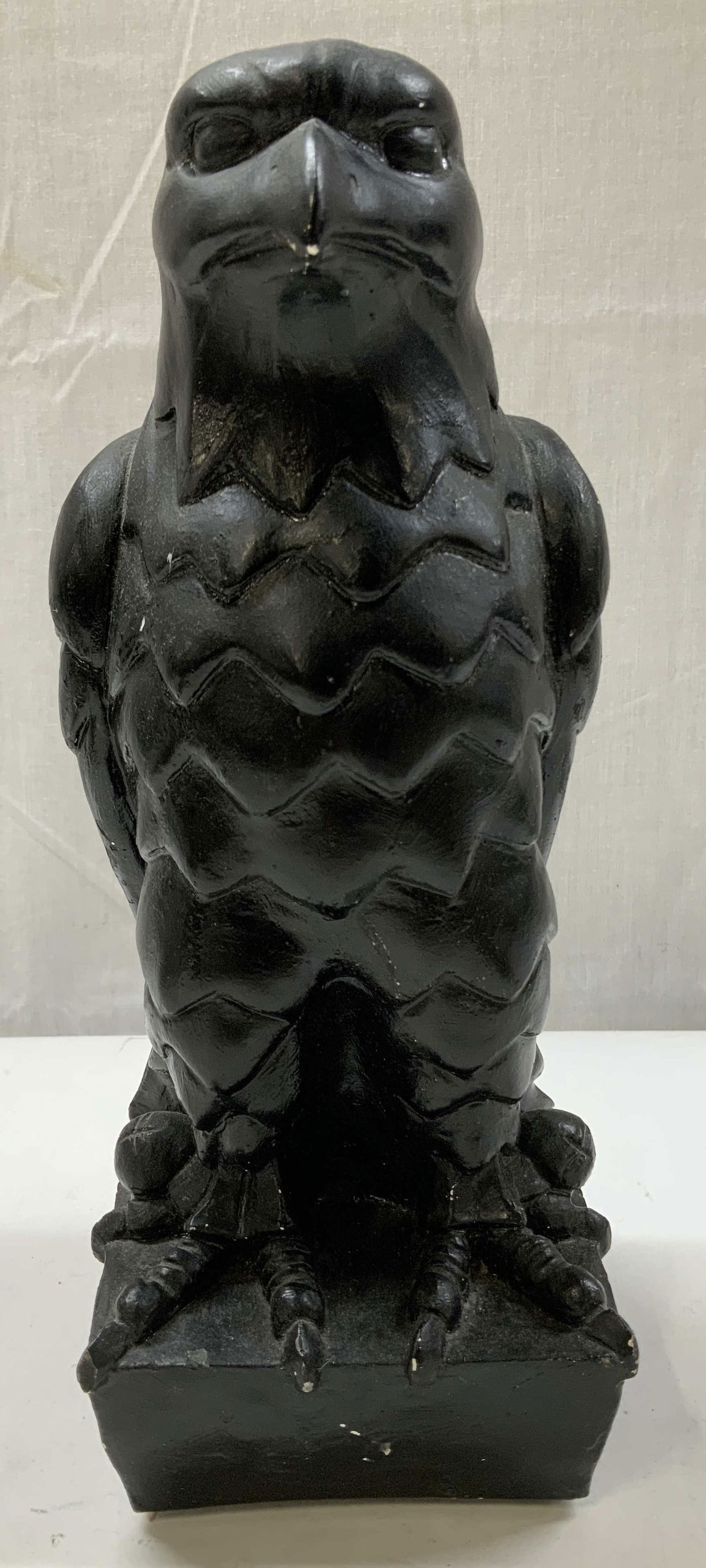 Black Maltese Falcon Replica Composite Statue: Replica of iconic Maltese Falcon statue, a famous film prop from 1941. Depicts a black falcon standing on a base with a textured, overlapping feather pattern. No visible signature or markings. Propert