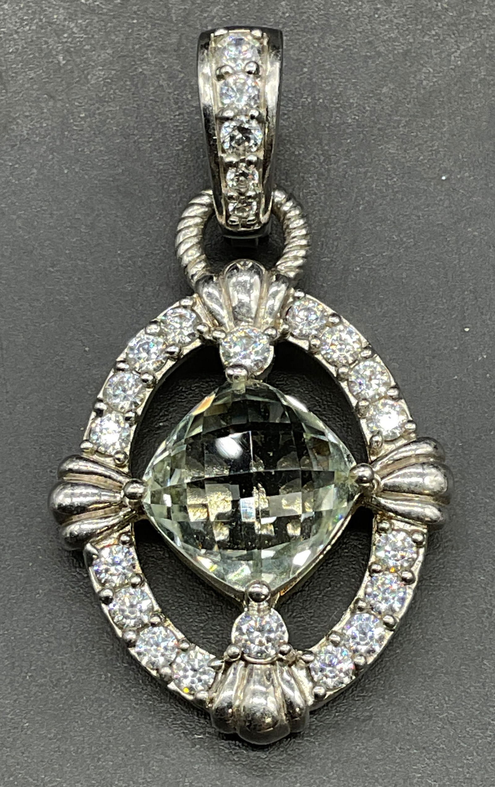 Judith Ripka Sterling Silver Semiprecious Pendant: Signed Judith Ripka sterling silver oval pendant with blue semiprecious stone and cubic zirconia accents. Marked sterling. Measures approx 1 x .75 inches. Total weight 9 grams. Some scratching. Jewelr