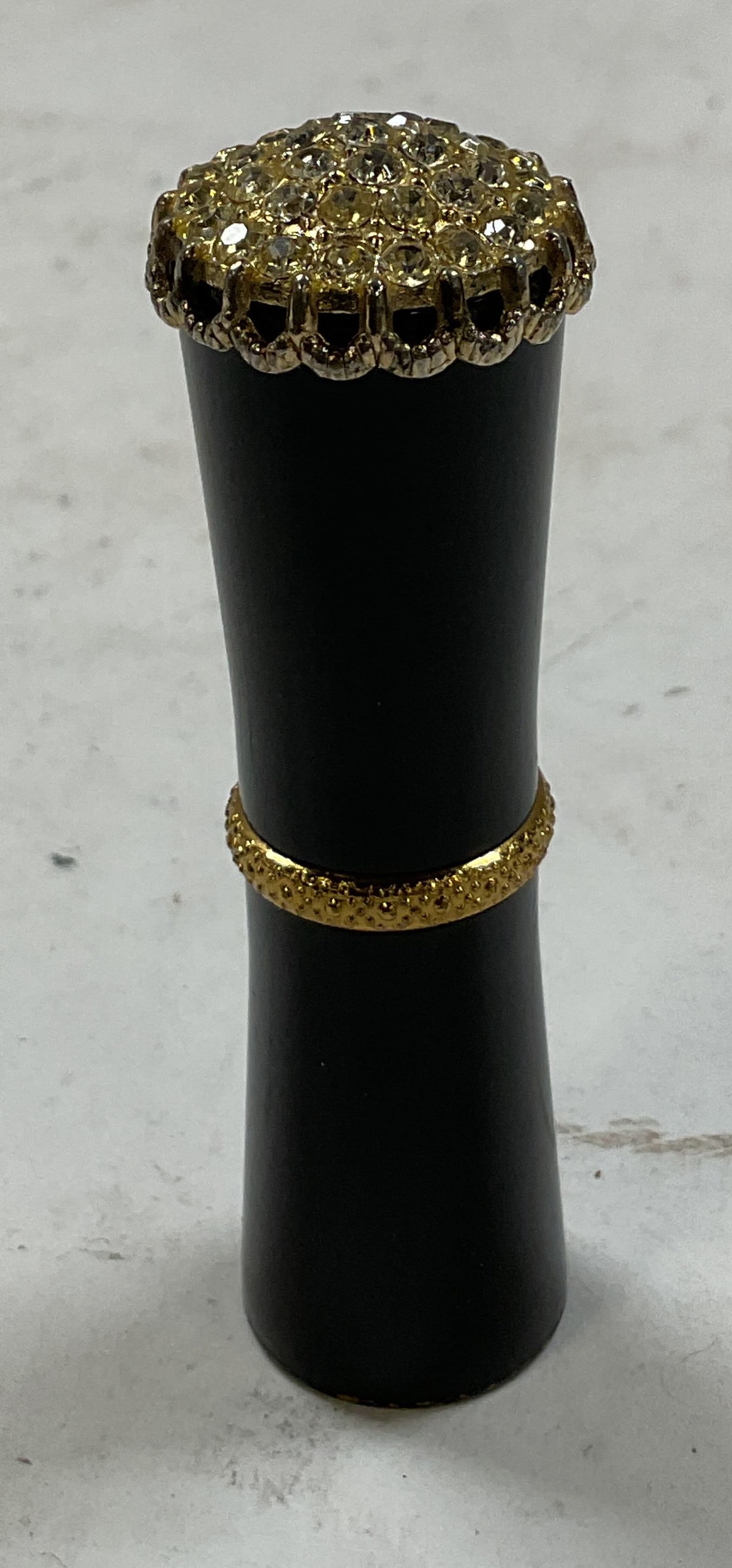 Vintage Revlon Futurama Lipstick Case: Vintage Revlon Futurama lipstick case. Solid black case with gold toned metal accents and top studded with clear rhinestones. Scalloped design. Reads Revlon 585 on underside. Measures approx 3