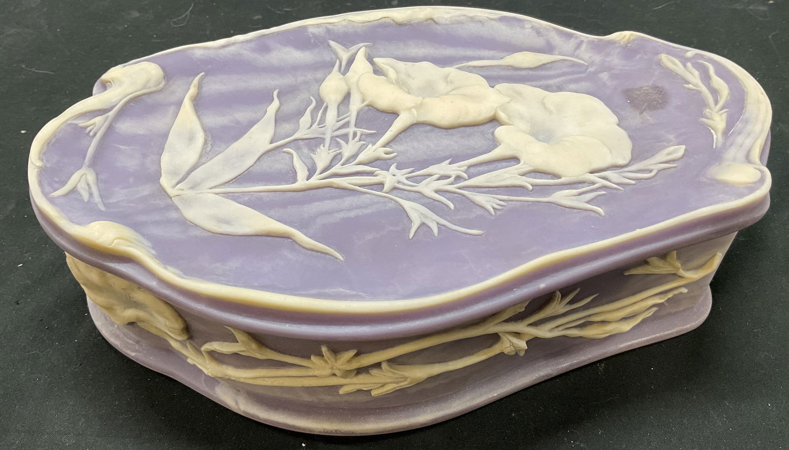 SGND Incolay Stone Hinged Trinket Box USA: Signed Incolay stone hinged trinket box. Sticker adhered to surface inside, reads as follows Genuine Incolay Stone Handcrafted USA. Signed Incolay on backside. Oval shaped box with hinges. Purple back