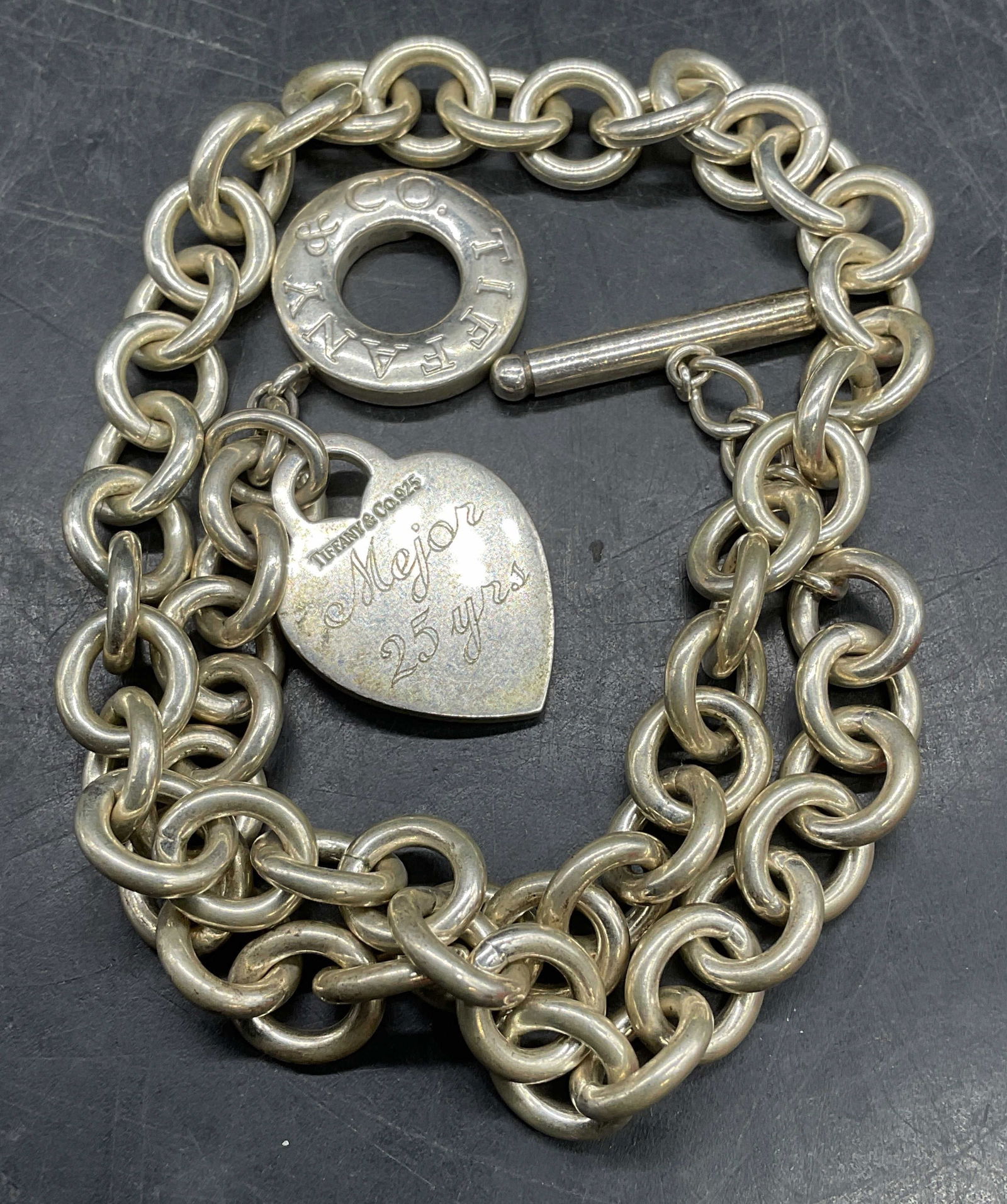 Tiffany Sterling Silver Classic Chain Necklace: Signed Tiffany & Co Sterling silver classic chain toggle clasp necklace with heart tag. Heart tag is engraved Mary/Mejor 25 yrs. Drop length approx 7.5 inches. Marked sterling. Total weight 76.5