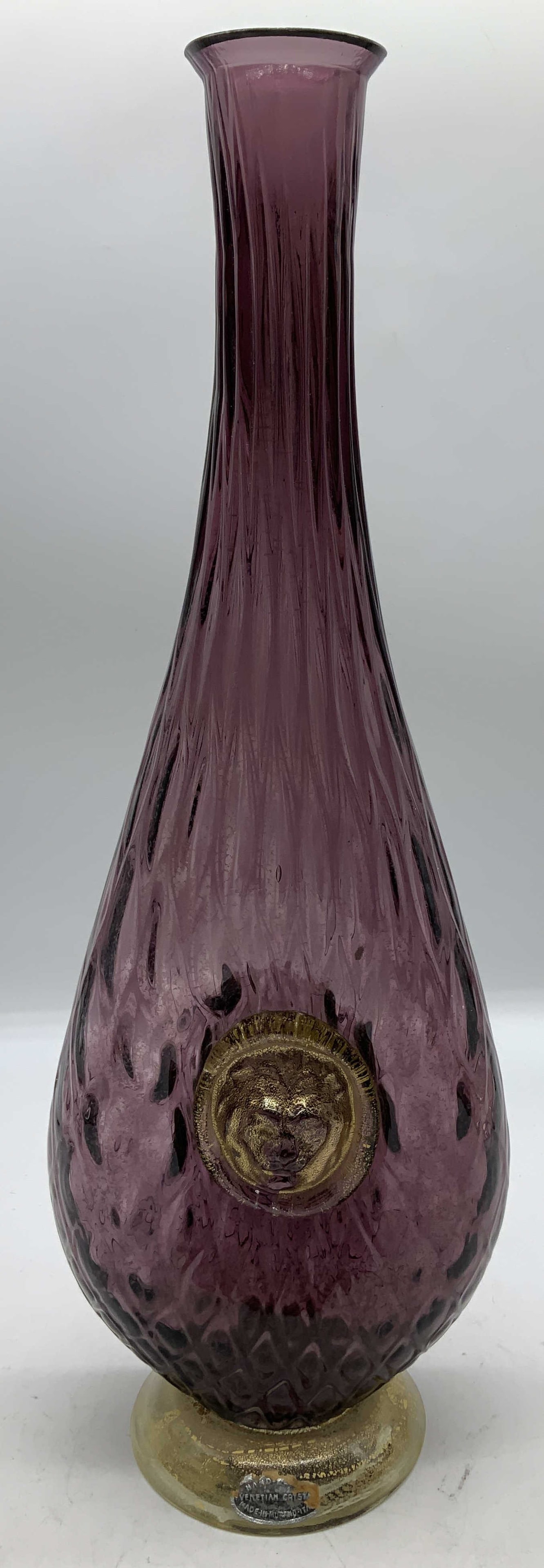 Vtg Murano Venetian Glass Vessel W Lion Head ITALY: Vintage Murano glass decanter with a purple hued body, gold speckled glass base & gilt figural lion head medallion. Hand blown. Signed & marked. Reads, HAND. VENETIAN. MADE IN MURANO ITALY. Rest of le