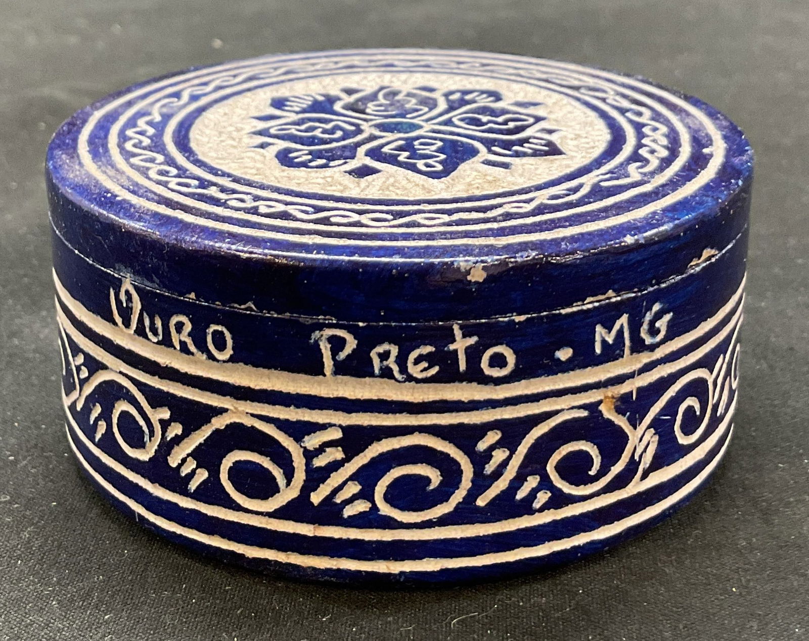 Vintage Hand Carved Ceramic Lidded Trinket Box: Vintage hand carved and hand painted ceramic lidded trinket box. Inscription on side, reads Ouro Preto MG. Circular box with lid. Blue background with carved designs. Swirl patterns and floral motifs.